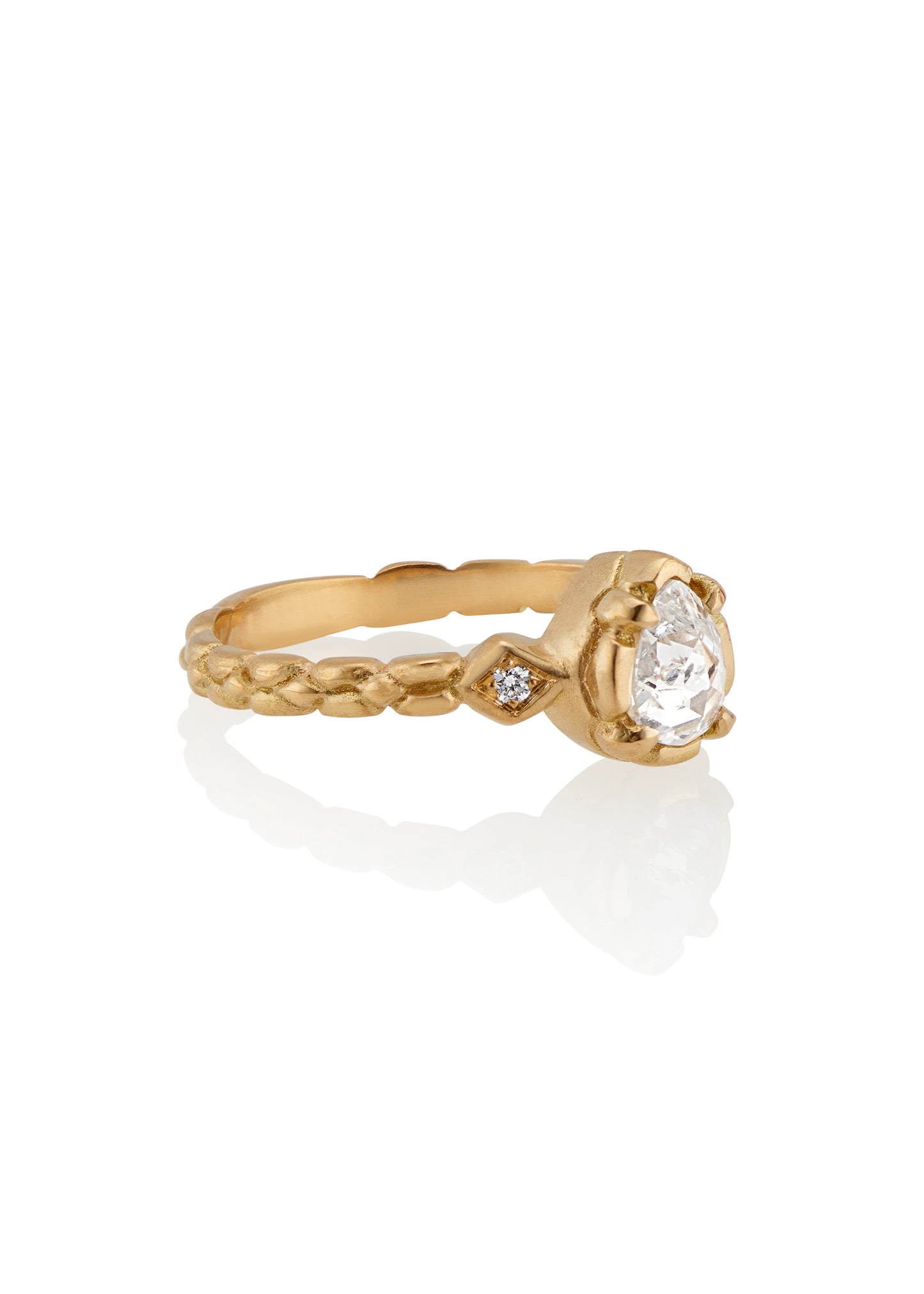 Stately and elegant, the Majestic ring is rich in exquisitely carved gold detail along the band, securing a pear-shaped rose cut diamond that commands attention—a piece evocative of royalty.