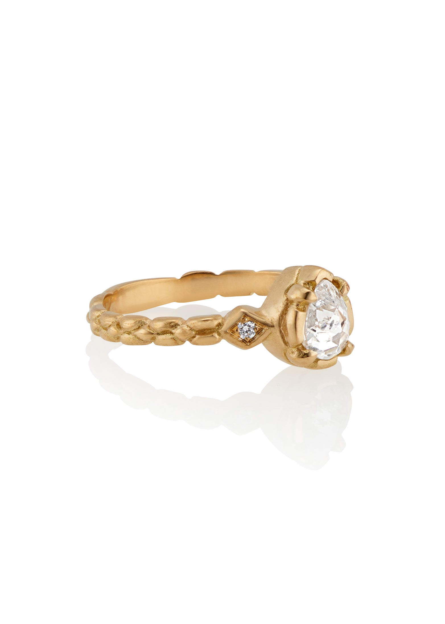 Stately and elegant, the Majestic ring is rich in exquisitely carved gold detail along the band, securing a pear-shaped rose cut diamond that commands attention—a piece evocative of royalty.