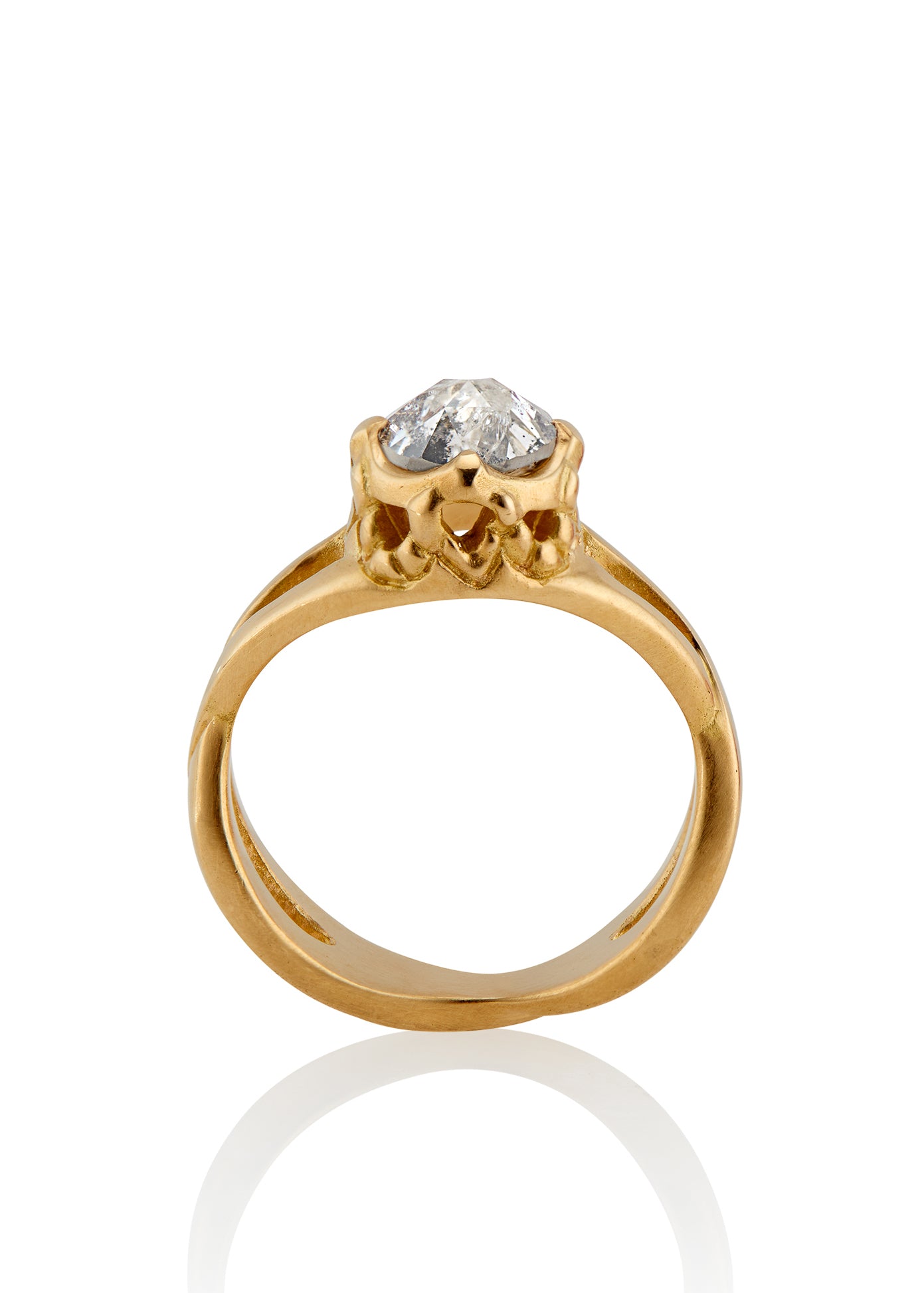 Capturing the Gothic beauty of a haunted mansion, the Liota ring is named for a woman whose gossamer spirit transcends time. Gold bands criss cross around the finger to buttress a brilliant rose cut diamond nestled among ornate carvings—an architectural ring that echoes the past while celebrating the eternal.