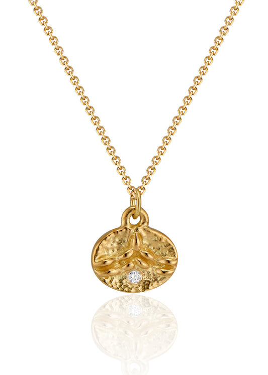 Inspired by the tiny beads of dew that cling to blades of grass on an early summer morning, the Dew necklace is hand-carved to reveal intricate texture and pattern across its coin-shaped pendant. A brilliant diamond catches the light, evocative of a dew drop itself—reflecting and refracting the beauty which surrounds it.