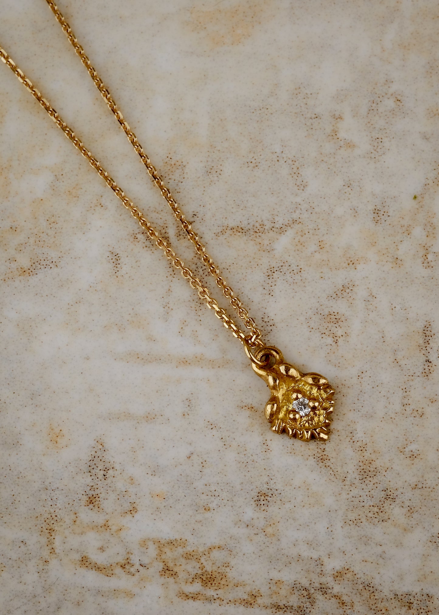 Like a small cabin nestled in the verdant mountainside of the Swiss Alps, the Chalet necklace invites a sense of wanderlust and adventure. Intricate textures give way to a single diamond that sparkles brilliantly against the gold that surrounds it—a snow-capped mountain top gleaming under the radiant warmth of the sun.