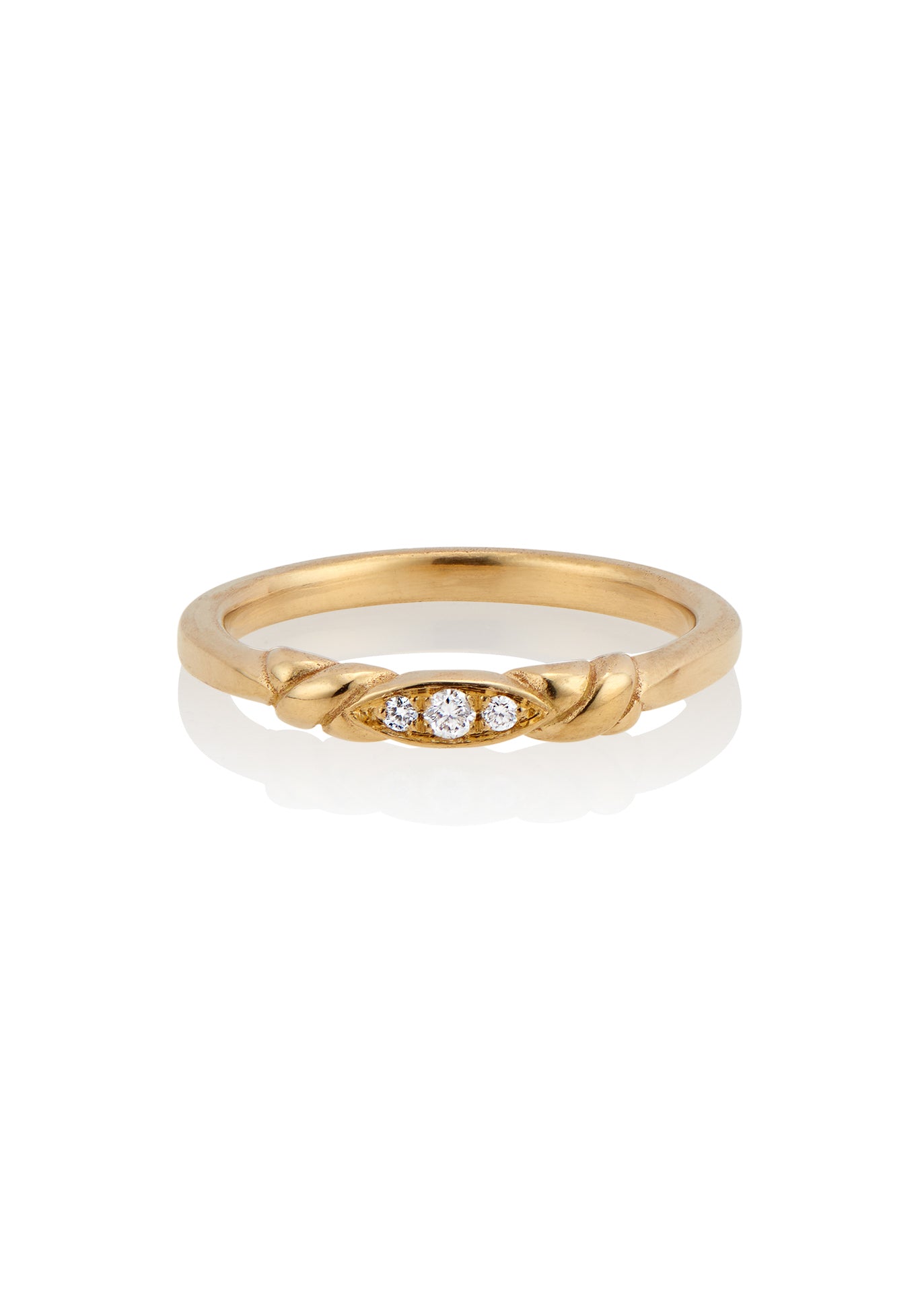 An engagement ring re-imagined, the Kiat ring was inspired by a proposal among sun-soaked cattails and waves lapping the shores of a hidden inlet. A gold band criss-crosses on either side of a trio of diamonds—a piece imbued with promise.