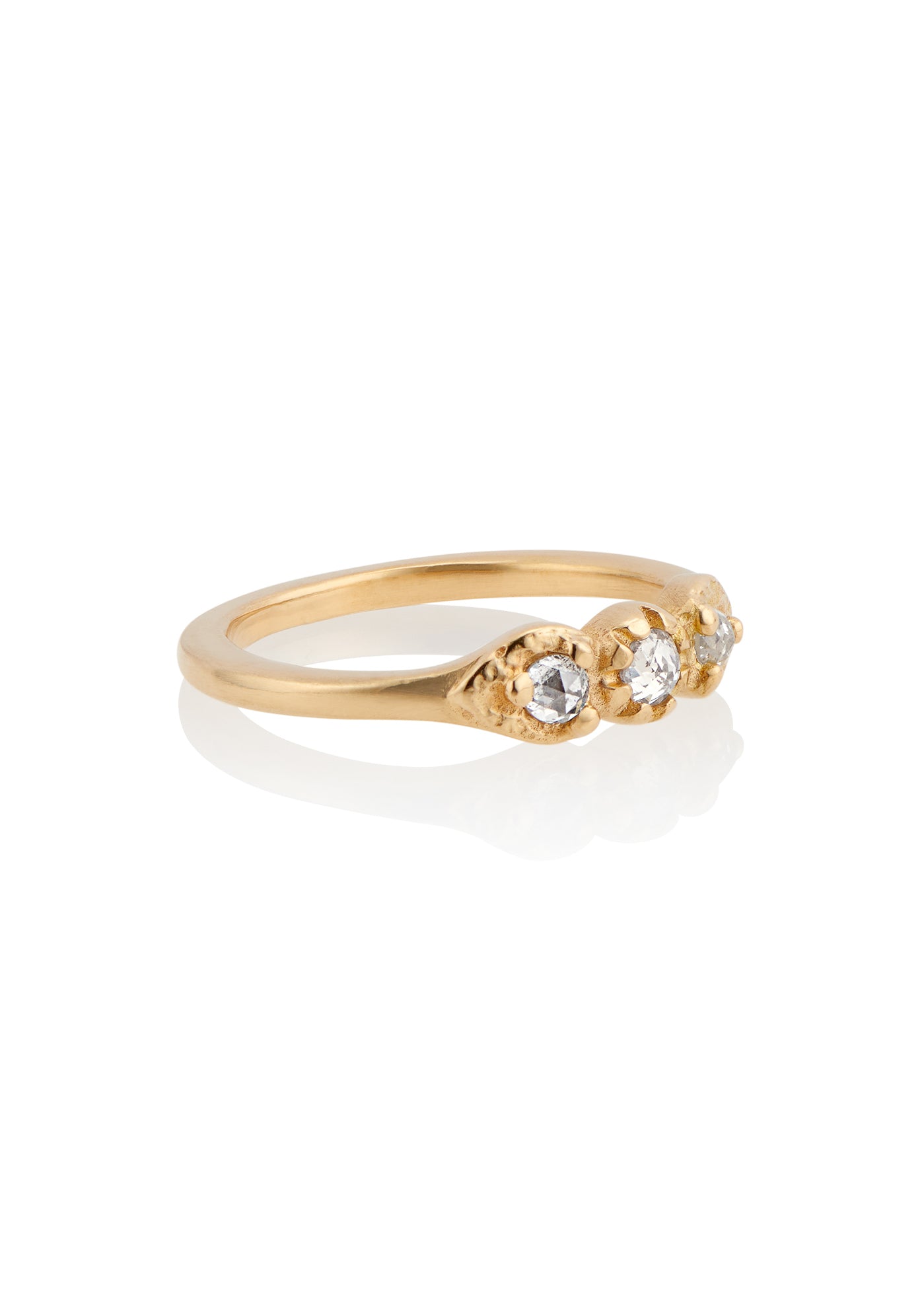 With a timeless and romantic aesthetic, the Trio ring showcases a gold band that has been hand-designed to create delicate beading and texture, encasing three luminous rose cut diamonds—an old world style reimagined for our modern moment.