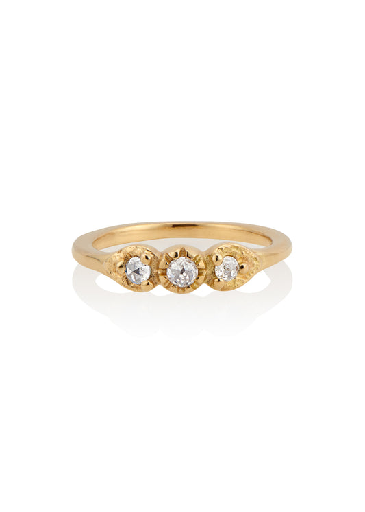 With a timeless and romantic aesthetic, the Trio ring showcases a gold band that has been hand-designed to create delicate beading and texture, encasing three luminous rose cut diamonds—an old world style reimagined for our modern moment.