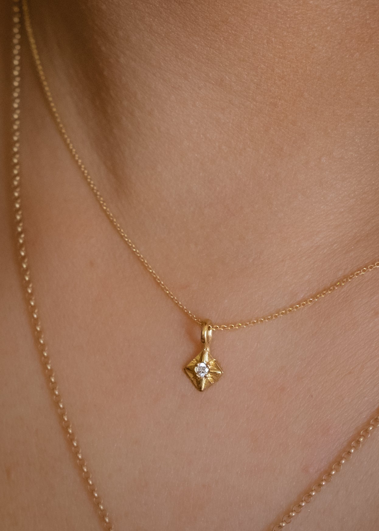 Through the sharp peak of a dormer window, a single star catches the eye: At the apex of the constellation it shines, as if hung by the starmaiden Astrea herself. Named for the Greek goddess, the Astrea necklace features a brilliant diamond that nestles between the zenith and nadir of a golden horizon. Hand-carved detail surrounding the diamond enhances its brilliance.