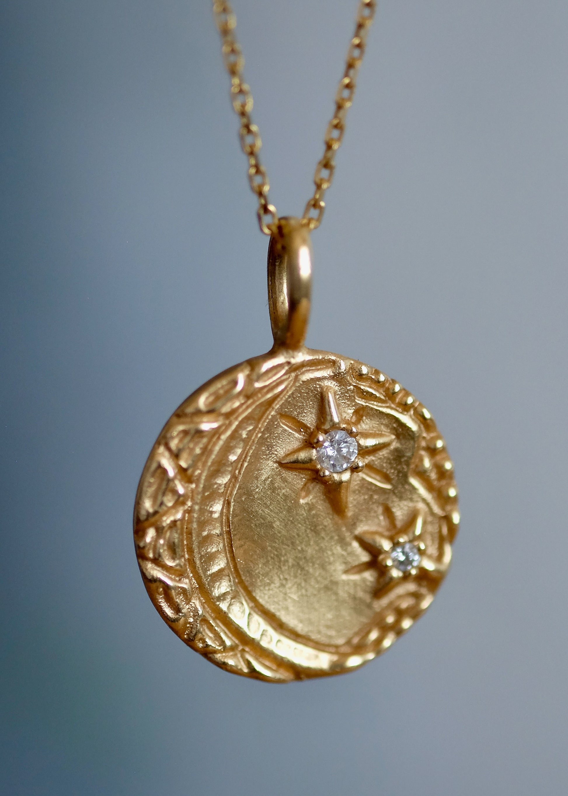 Cheers to the night owls. To the tender souls who create magic in the dark, who carry the secrets of the stars. The Night Owl is a gold pendant necklace that shines with a delicate, hand-textured crescent moon that cradles two diamond stars–an homage to an eternal love that exists beyond boundaries of space and time.