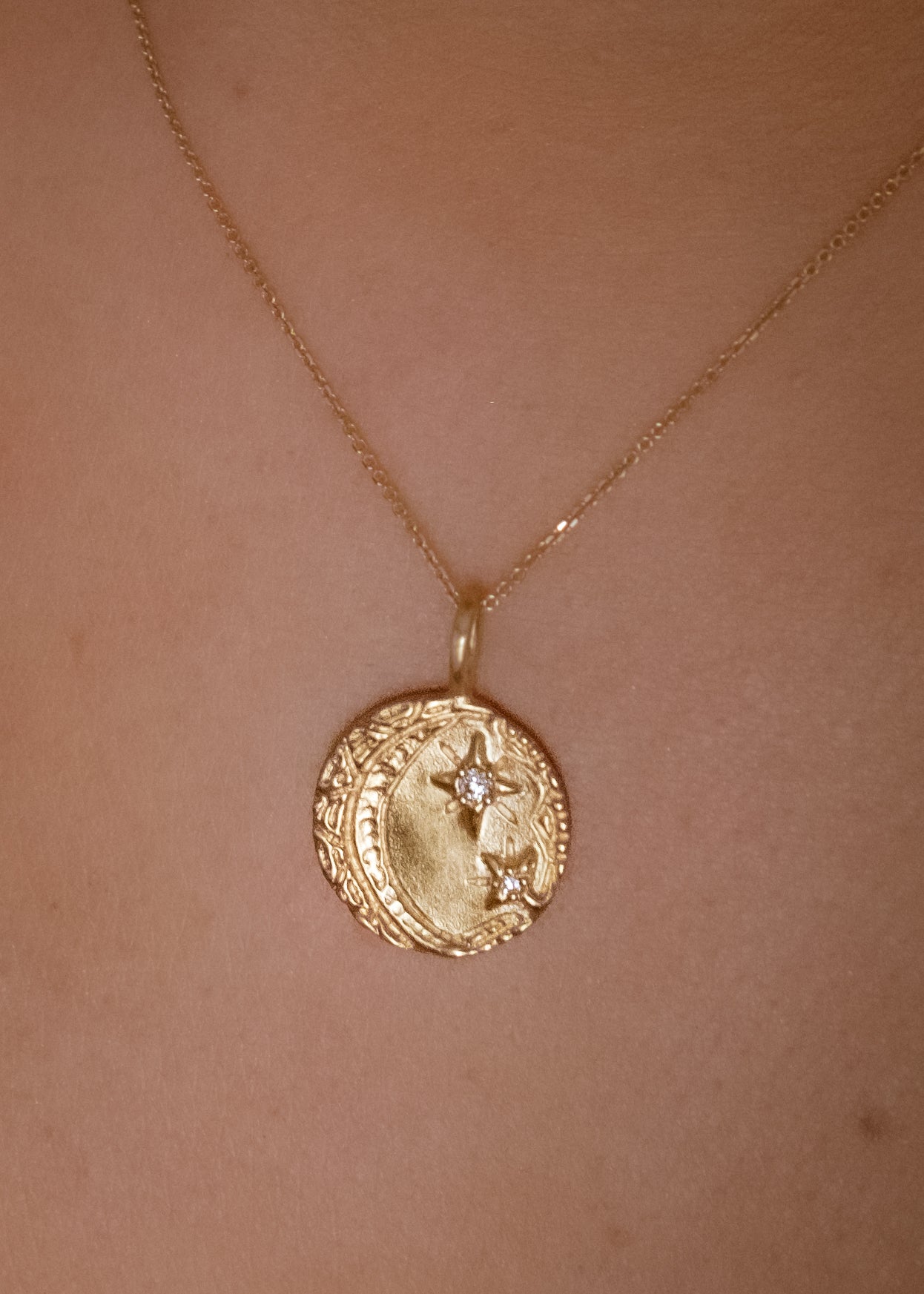 Cheers to the night owls. To the tender souls who create magic in the dark, who carry the secrets of the stars. The Night Owl is a gold pendant necklace that shines with a delicate, hand-textured crescent moon that cradles two diamond stars–an homage to an eternal love that exists beyond boundaries of space and time.