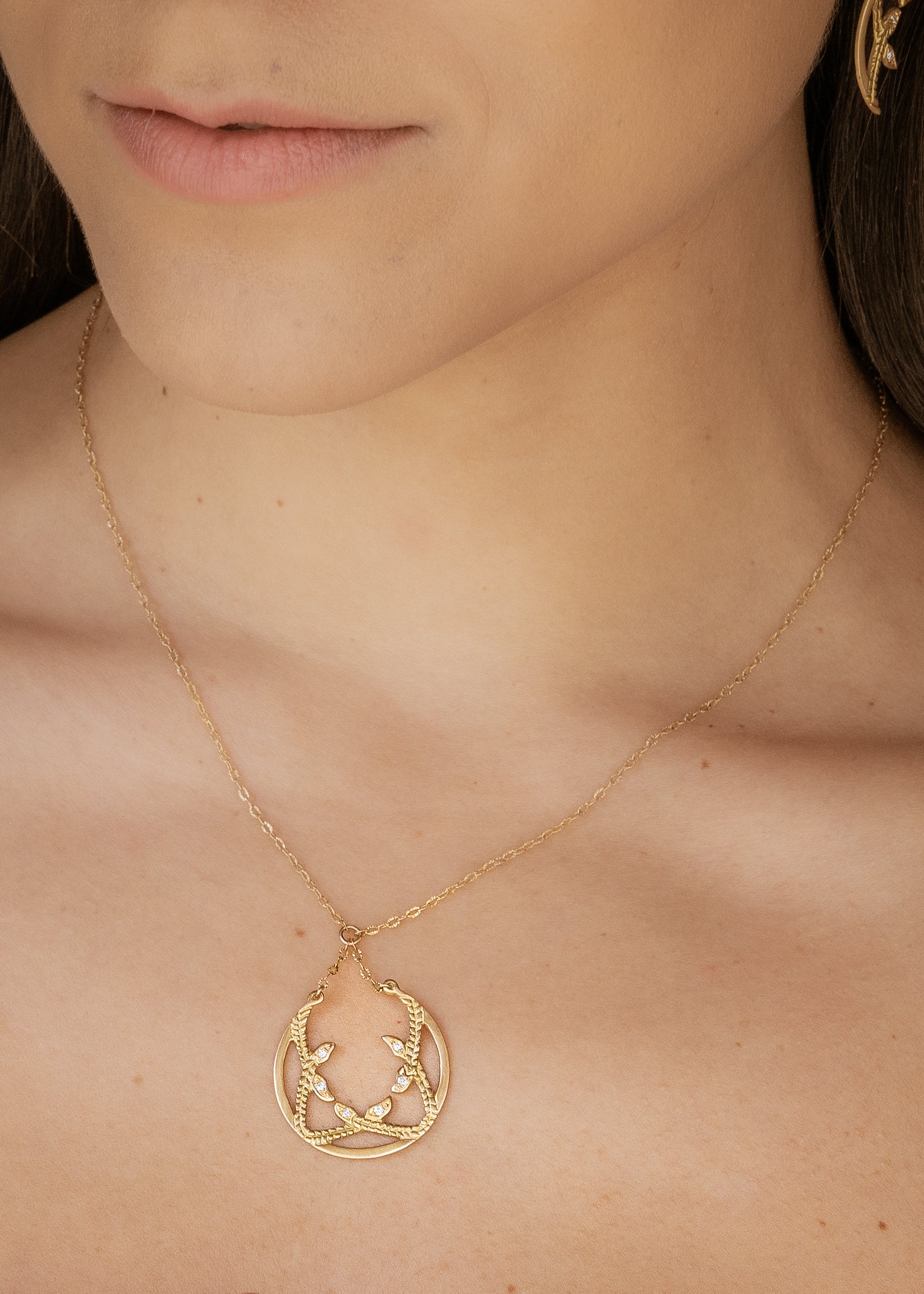 Inspired by the female prophets who share its name, the Sibyl necklace whispers the mysteries of the future while echoing stories of days past. Smooth open-work crescents give way to intertwining textured elements, hand-carved to draw the eye in and reveal brilliant diamond accents—a substantial and haunting design that’s decidedly feminine.