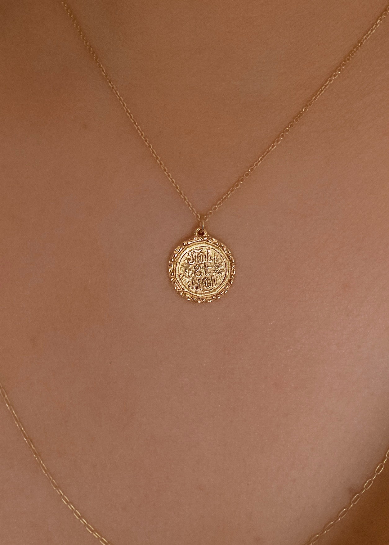 Inspired by “toi et moi” engagement rings from centuries past, the Toi et Moi necklace is a gold pendant engraved by hand to read “Toi et Moi” on one side and “You and Me” on the other. Delicate carving on the edges showcases the beauty of the gold—a piece that’s romantic, sweet, and a promise of things to come.