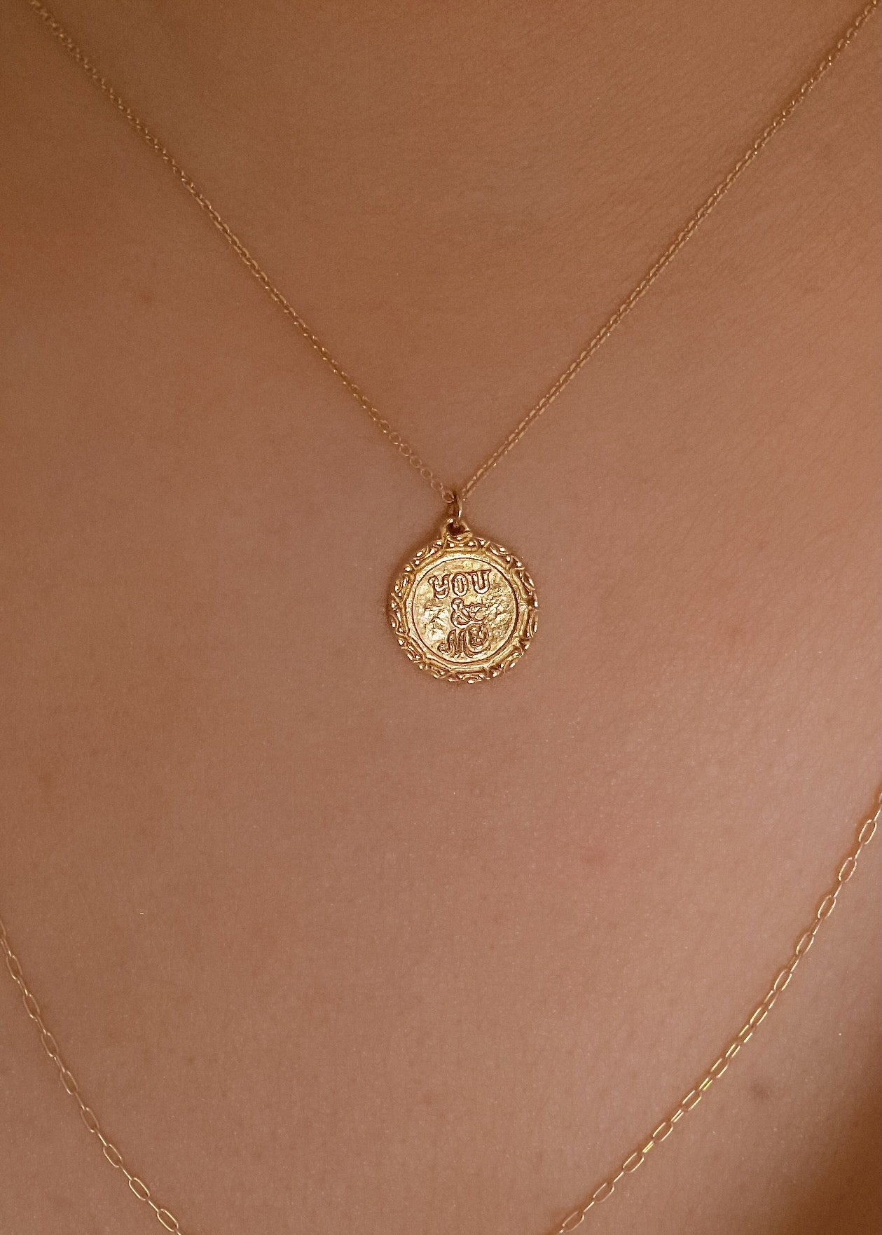 Inspired by “toi et moi” engagement rings from centuries past, the Toi et Moi necklace is a gold pendant engraved by hand to read “Toi et Moi” on one side and “You and Me” on the other. Delicate carving on the edges showcases the beauty of the gold—a piece that’s romantic, sweet, and a promise of things to come.