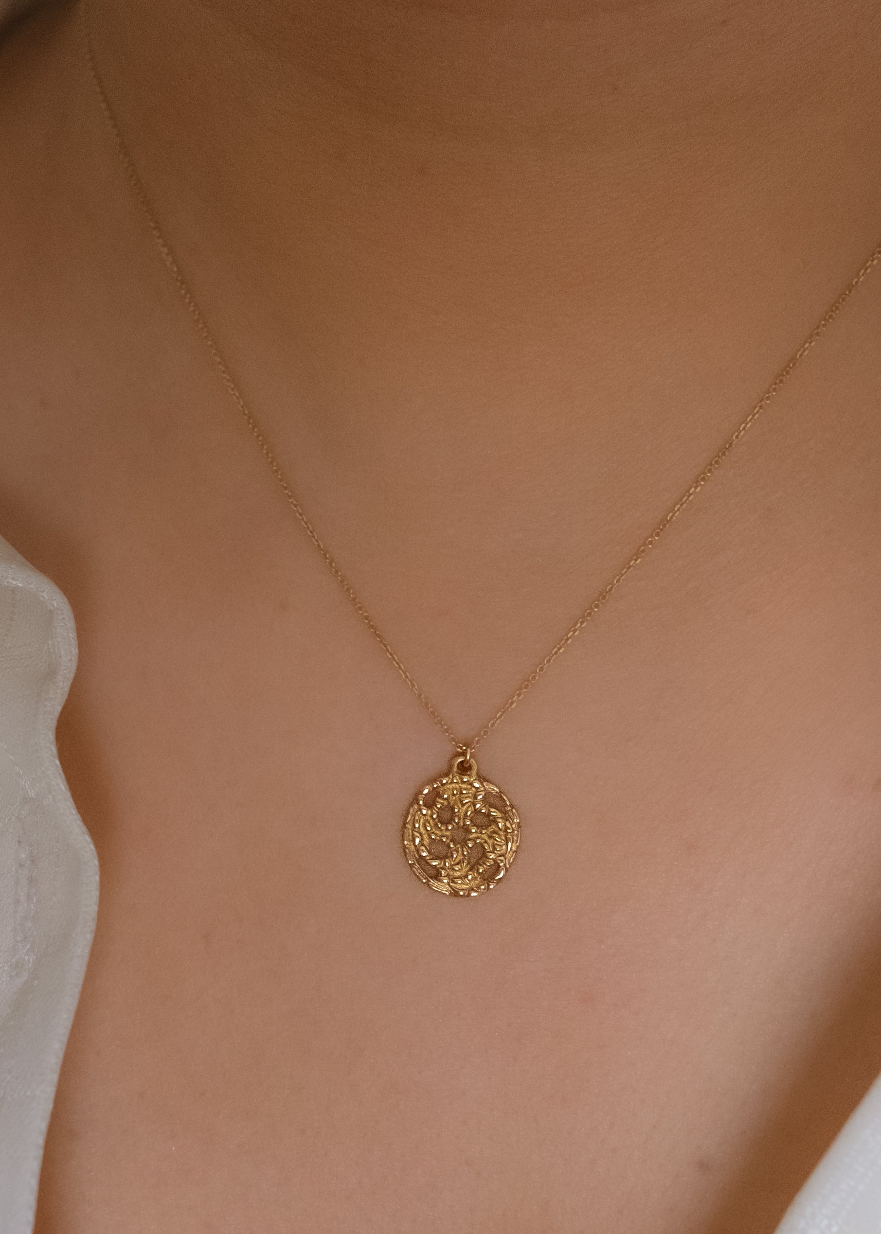 A passport to another world. With its intricate hand-carved texture and open-work design, the Token necklace calls to mind a lucky coin that opens the gate to where adventure lies, just beyond.