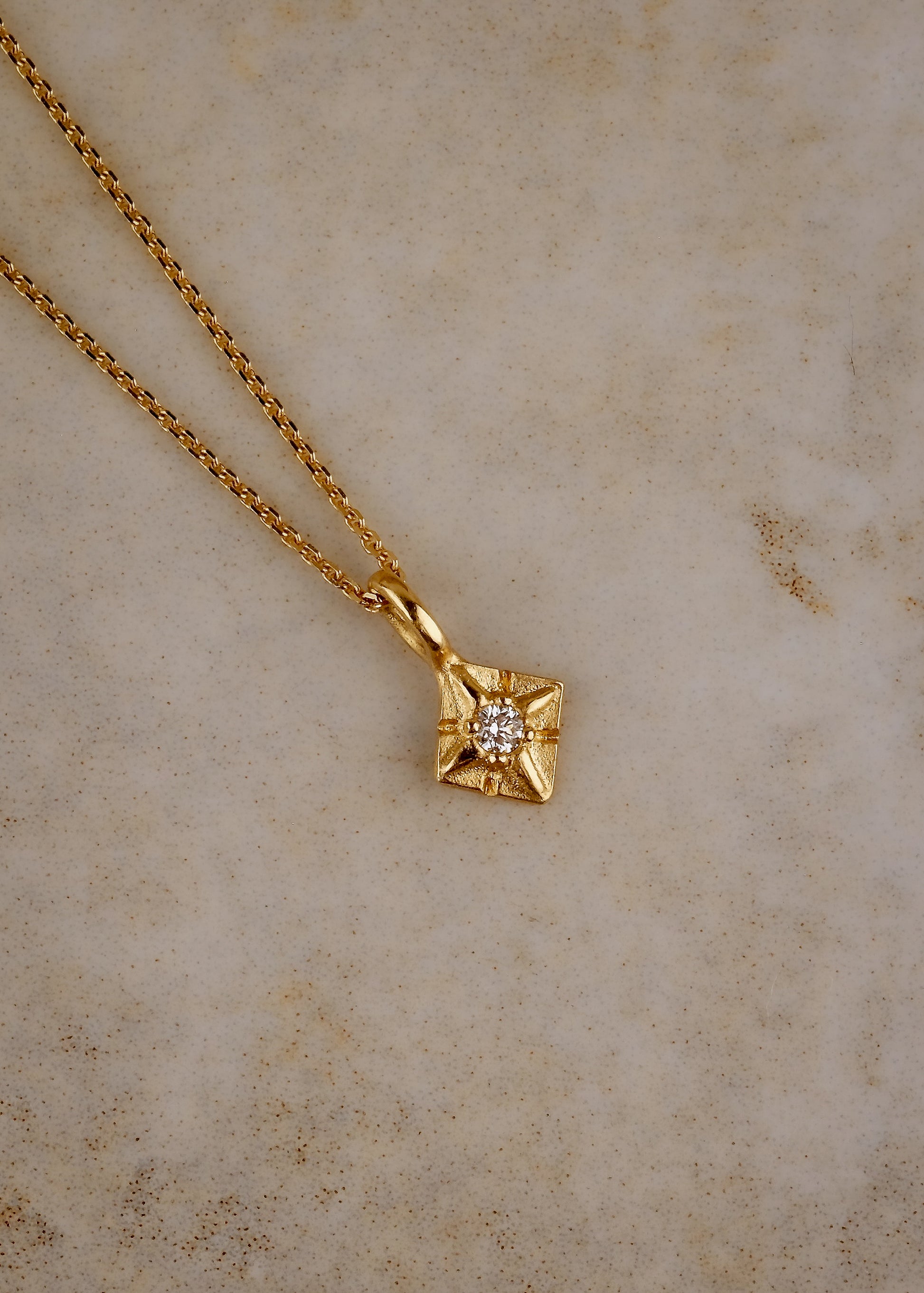 Through the sharp peak of a dormer window, a single star catches the eye: At the apex of the constellation it shines, as if hung by the starmaiden Astrea herself. Named for the Greek goddess, the Astrea necklace features a brilliant diamond that nestles between the zenith and nadir of a golden horizon. Hand-carved detail surrounding the diamond enhances its brilliance.