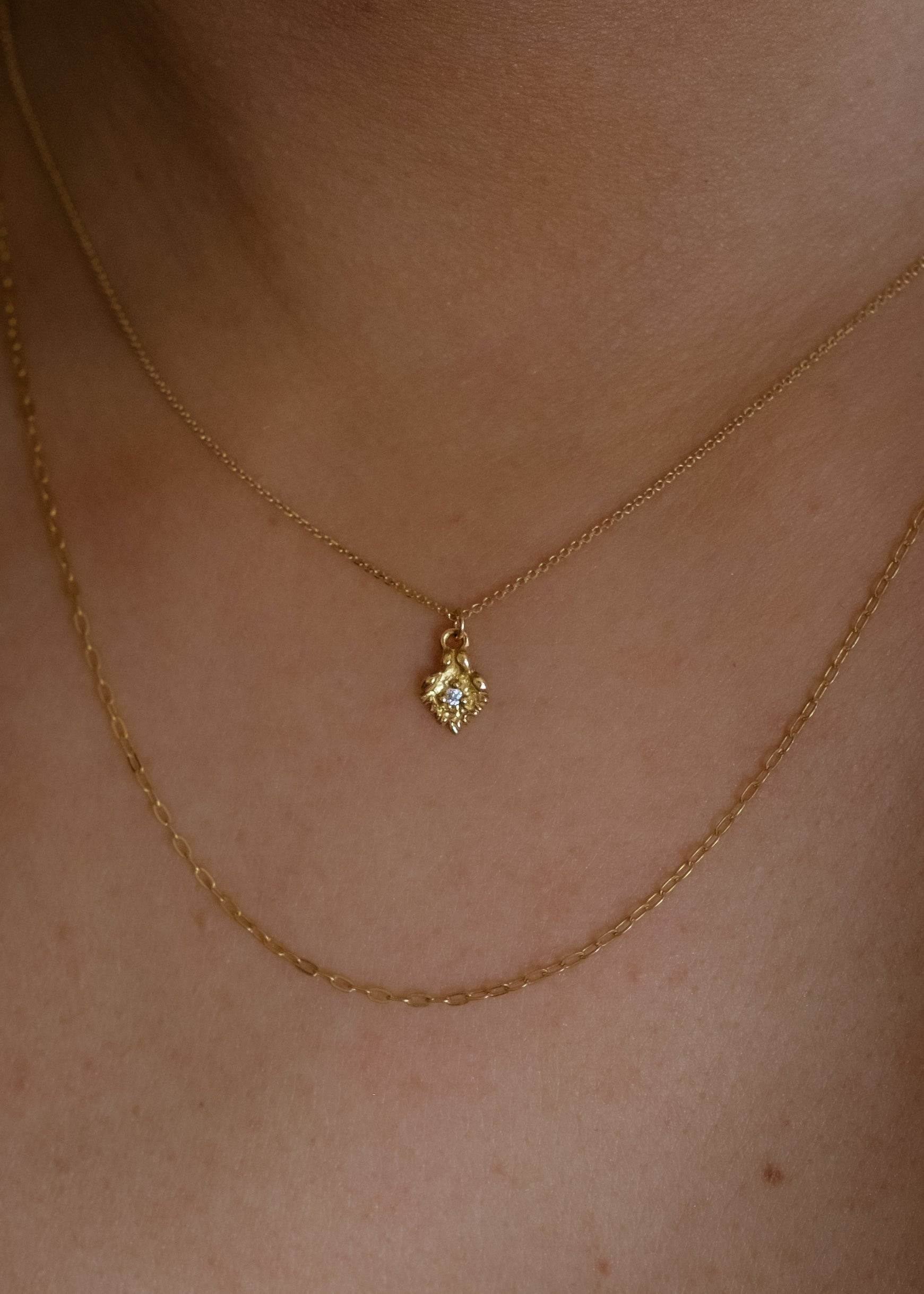 Like a small cabin nestled in the verdant mountainside of the Swiss Alps, the Chalet necklace invites a sense of wanderlust and adventure. Intricate textures give way to a single diamond that sparkles brilliantly against the gold that surrounds it—a snow-capped mountain top gleaming under the radiant warmth of the sun.