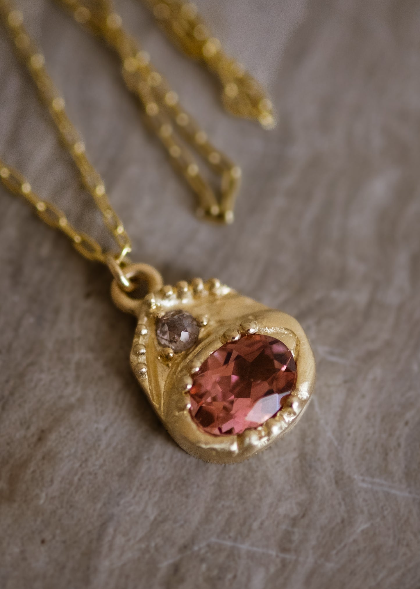 Beyond the creaking floorboards of the antique shop stands a curio cabinet, a sentinel of small treasures redolent with tales of love and lore. Inspired by these cabinets that hold such rare objects, the Curio necklace shines with a stunning oval tourmaline. A rose cut diamond hovers above, a shining crown punctuated by delicate hand-carved gold beads–a necklace worthy of telling your story for generations to come.