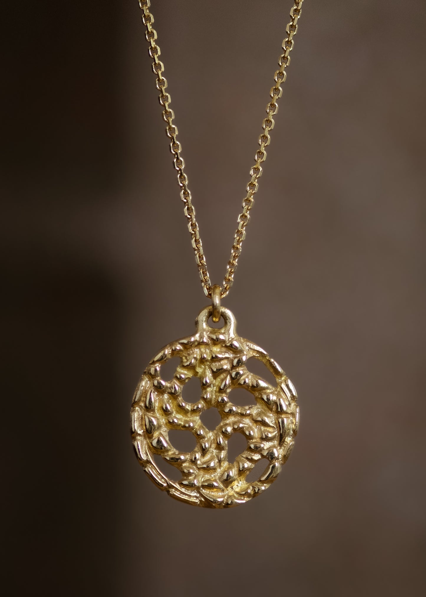 A passport to another world. With its intricate hand-carved texture and open-work design, the Token necklace calls to mind a lucky coin that opens the gate to where adventure lies, just beyond.