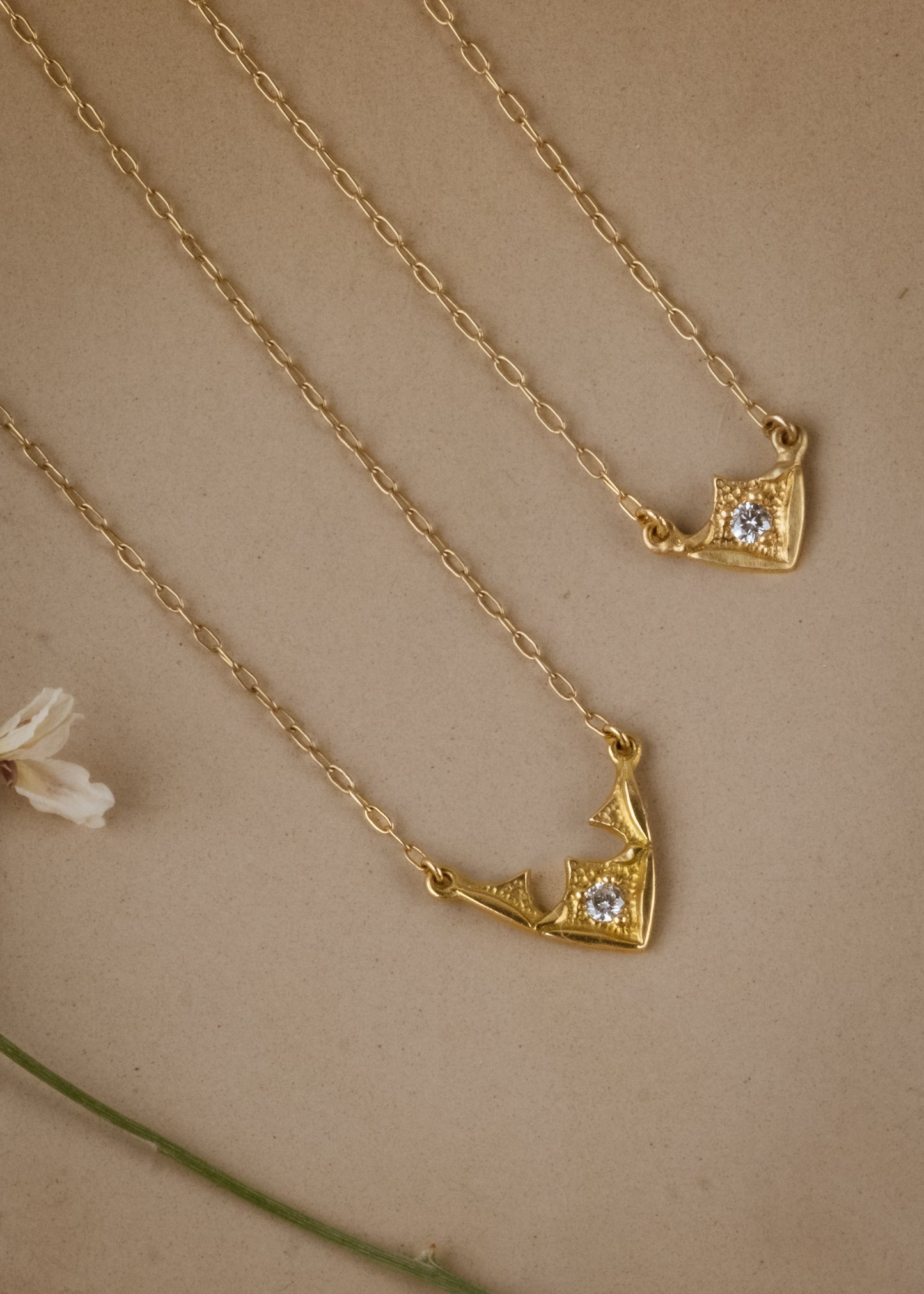 Taken from the French word for “vault,” the Volta necklace is an homage to the Gothic architecture of Paris. Gentle sloping curves give way to acute points, evoking the grandeur of a centuries-old cathedral ceiling. A single diamond catches the eye, complemented by ornate texture and delicate beading—a necklace that transcends time and transports the imagination.