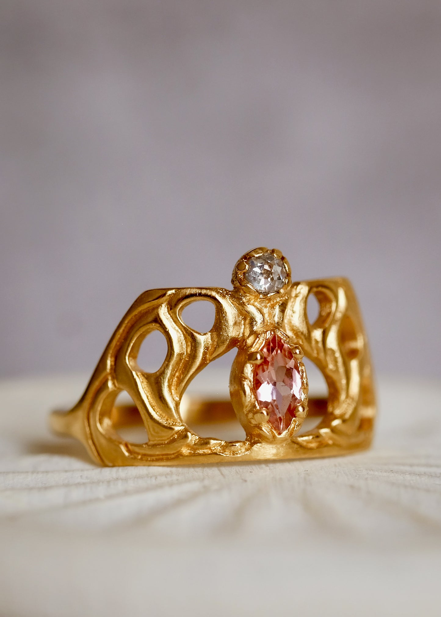 Framed by an intricate open-work pattern, the Anthea ring imagines the Greek goddess rendered in a window of stained glass, cradled by serpentine mullions of gleaming gold. A stunning tourmaline stone and rose cut diamond create a sensuous silhouette on this ring that bears her name.