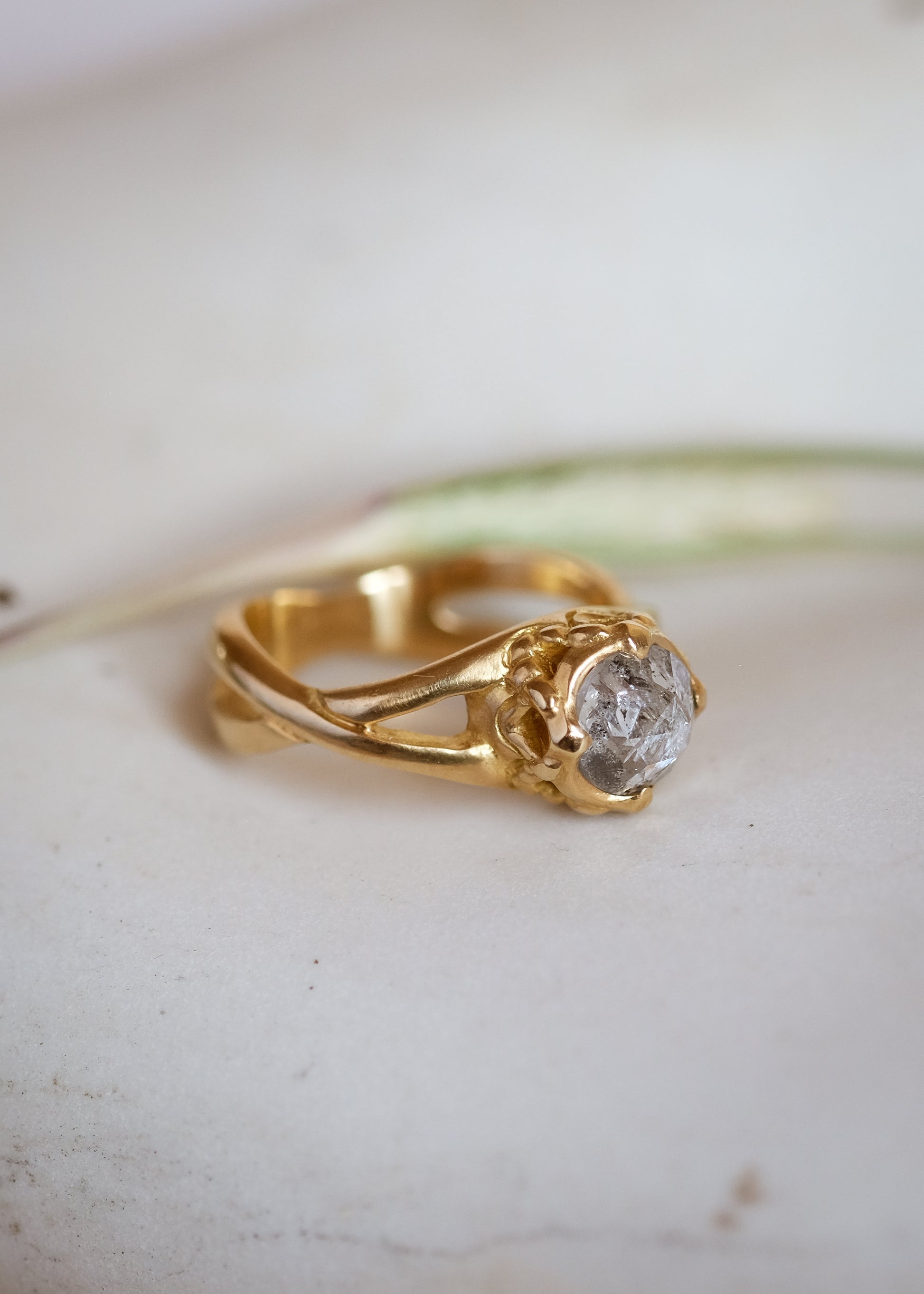 Capturing the Gothic beauty of a haunted mansion, the Liota ring is named for a woman whose gossamer spirit transcends time. Gold bands criss cross around the finger to buttress a brilliant rose cut diamond nestled among ornate carvings—an architectural ring that echoes the past while celebrating the eternal.