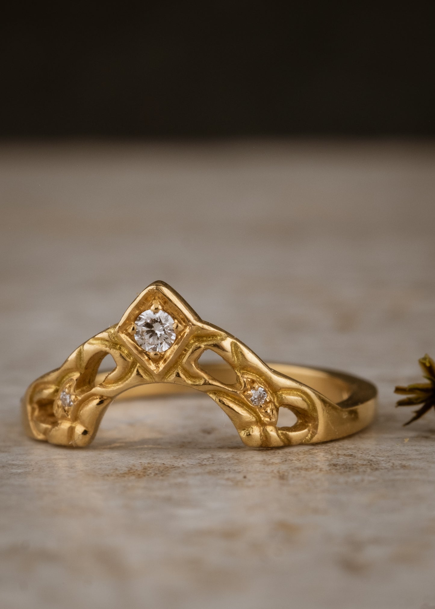 Created for a friend to perfectly compliment her engagement ring, the Empress is a nesting ring that evokes a priceless tiara. A diamond sits high atop an arched band, hand-carved with intricate detail. Two smaller diamonds sparkle on either side, creating a timeless and cherished heirloom.