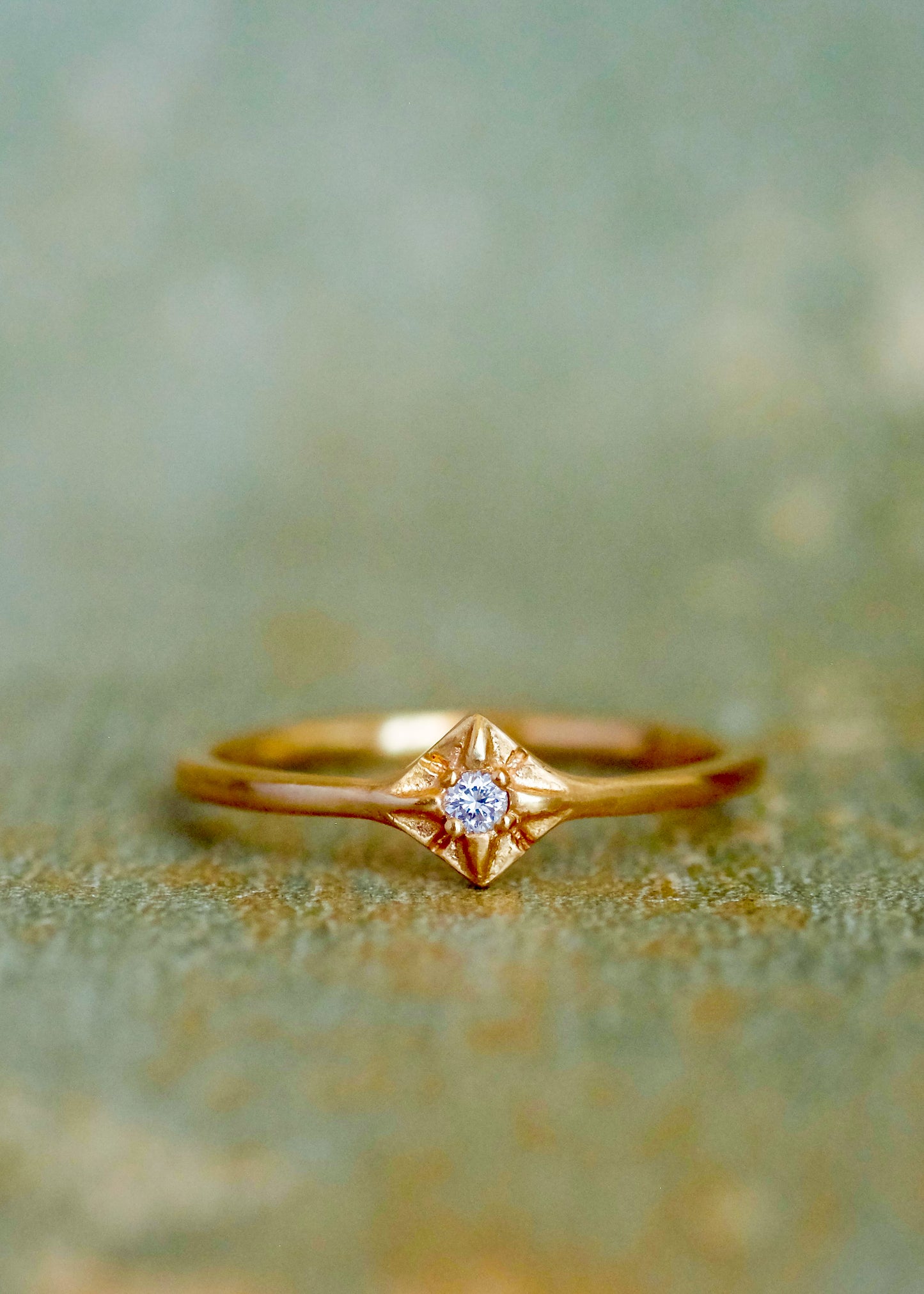 Through the sharp peak of a dormer window, a single star catches the eye: At the apex of the constellation it shines, as if hung by the starmaiden Astrea herself. Named for the Greek goddess, the Astrea ring features an understated band that encircles the finger to give way to a brilliant diamond that nestles between the zenith and nadir of a golden horizon. Hand-carved detail surrounding the diamond enhances its brilliance.