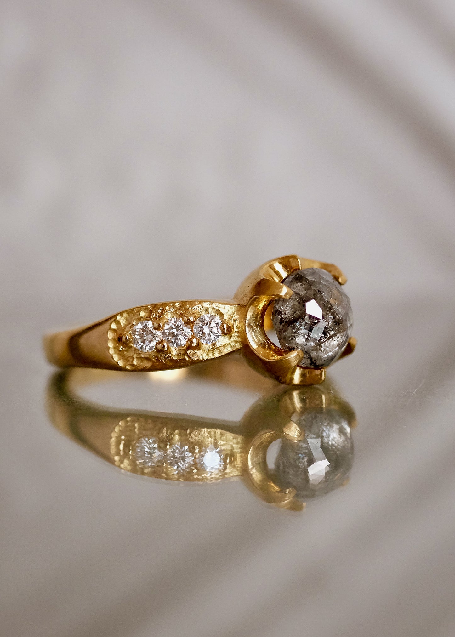 Inspired by the mesmerizing solo by musician Maxence Cyrin, the Gradiva ring embodies both the resonant chords and whimsical trills of the piano in a piece that marries substance with ethereal beauty. Brilliant inlaid diamonds adorn the band of the ring as a precious rose cut diamond sits prominently within the gold prongs—an heirloom-worthy ring to be cherished for generations.