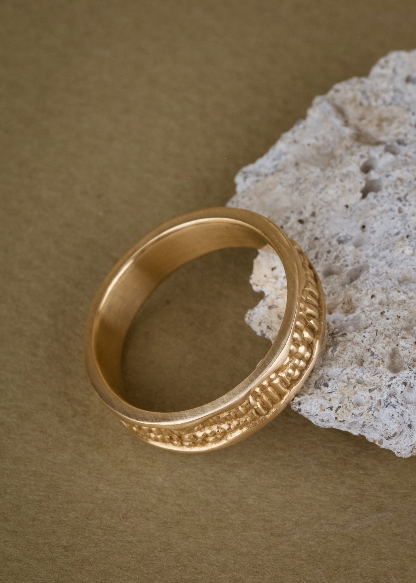 Inspired by the craftsmanship of intricately carved antique woodwork, the Hilt is a study in solidity. A captivating pattern gleams around this gold ring—an ideal wedding band for one with a discerning eye for design.