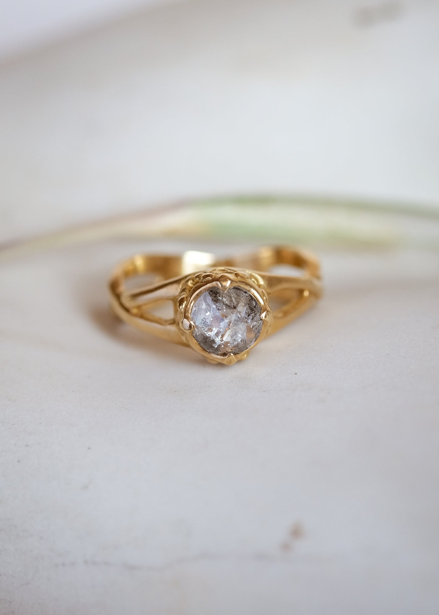Capturing the Gothic beauty of a haunted mansion, the Liota ring is named for a woman whose gossamer spirit transcends time. Gold bands criss cross around the finger to buttress a brilliant rose cut diamond nestled among ornate carvings—an architectural ring that echoes the past while celebrating the eternal.