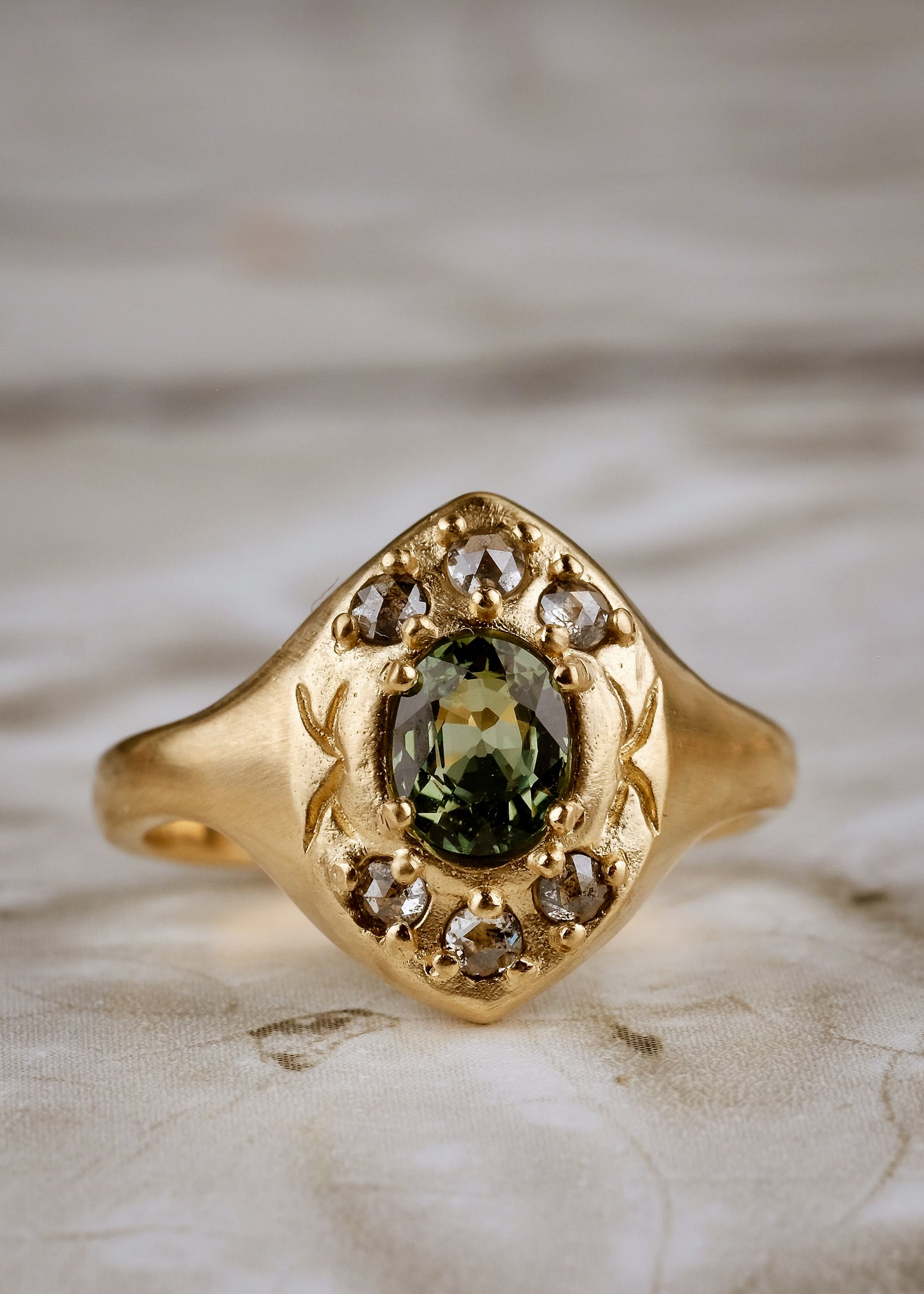 A resplendent portal to a bygone era, the Lucent ring borrows inspiration from the Gothic arches of a treasured riverside cathedral. Aligned to highlight the points of the arches, rose cut diamonds and a breathtaking green sapphire appear lit from within, like sunlight streaming through stained glass. A masterful, timeless piece of jewelry.