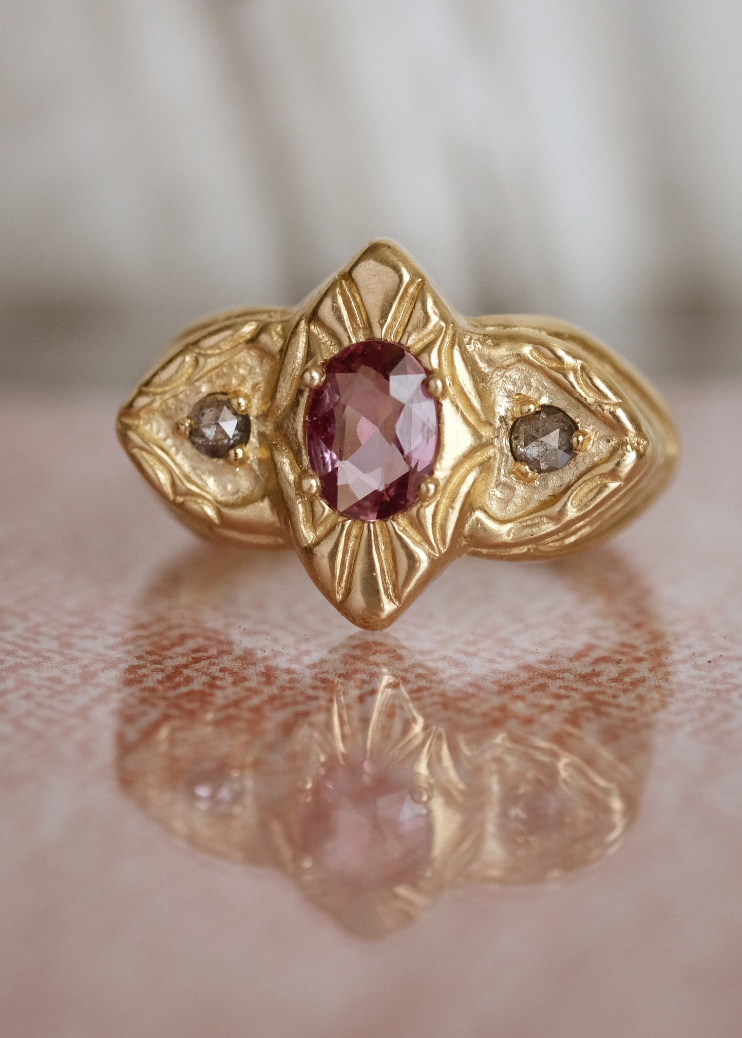 On a brisk evening, the golden warmth of a softly-lit room beckons to passersby– a glance of life beyond the facade. Like that ambient glow, the Pavillion ring seduces the eye with a precious sapphire and rose cut diamonds that nestle amid hand-carved gold, the gentle curves of the ring like eyelid dormer windows that beguile with a glance of what lies just beyond.