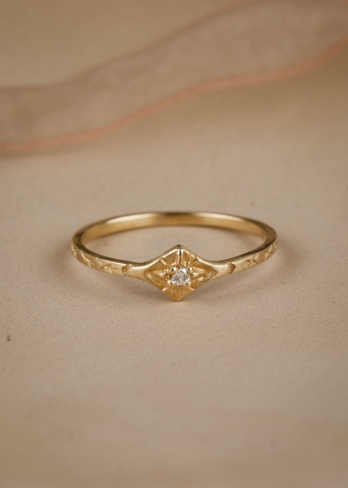 The smoke from a wood burning fire. A brilliant point of light piercing an obsidian sky. The Starlite ring captures the beauty of a frigid winter night. A brilliant diamond gleams against a delicate gold band that’s been intricately hand-carved with stars–a piece as timeless as the constellations themselves.