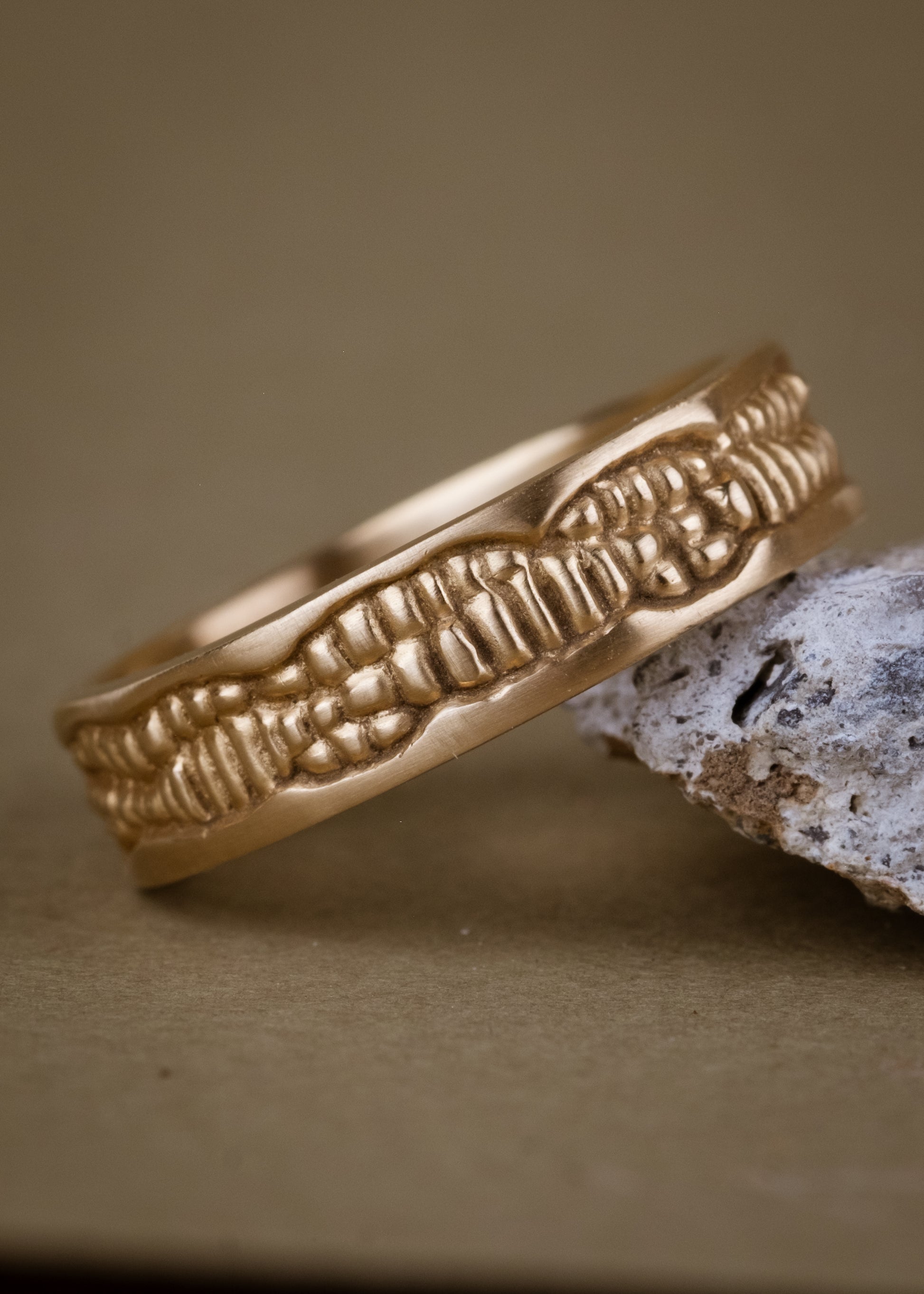 Inspired by the craftsmanship of intricately carved antique woodwork, the Hilt is a study in solidity. A captivating pattern gleams around this gold ring—an ideal wedding band for one with a discerning eye for design.