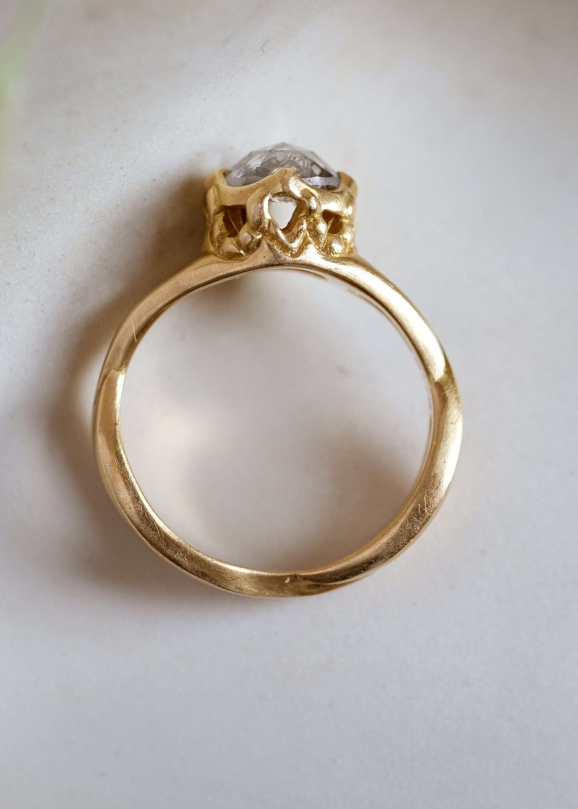 Capturing the Gothic beauty of a haunted mansion, the Liota ring is named for a woman whose gossamer spirit transcends time. Gold bands criss cross around the finger to buttress a brilliant rose cut diamond nestled among ornate carvings—an architectural ring that echoes the past while celebrating the eternal.