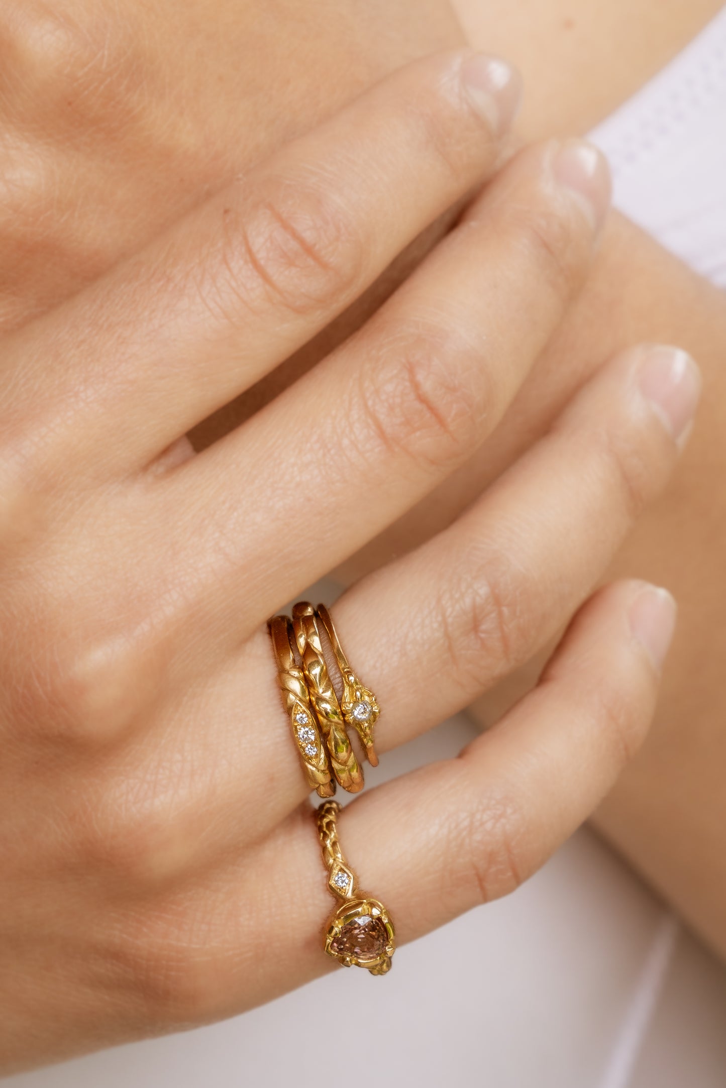 An engagement ring re-imagined, the Kiat ring was inspired by a proposal among sun-soaked cattails and waves lapping the shores of a hidden inlet. A gold band criss-crosses on either side of a trio of diamonds—a piece imbued with promise.