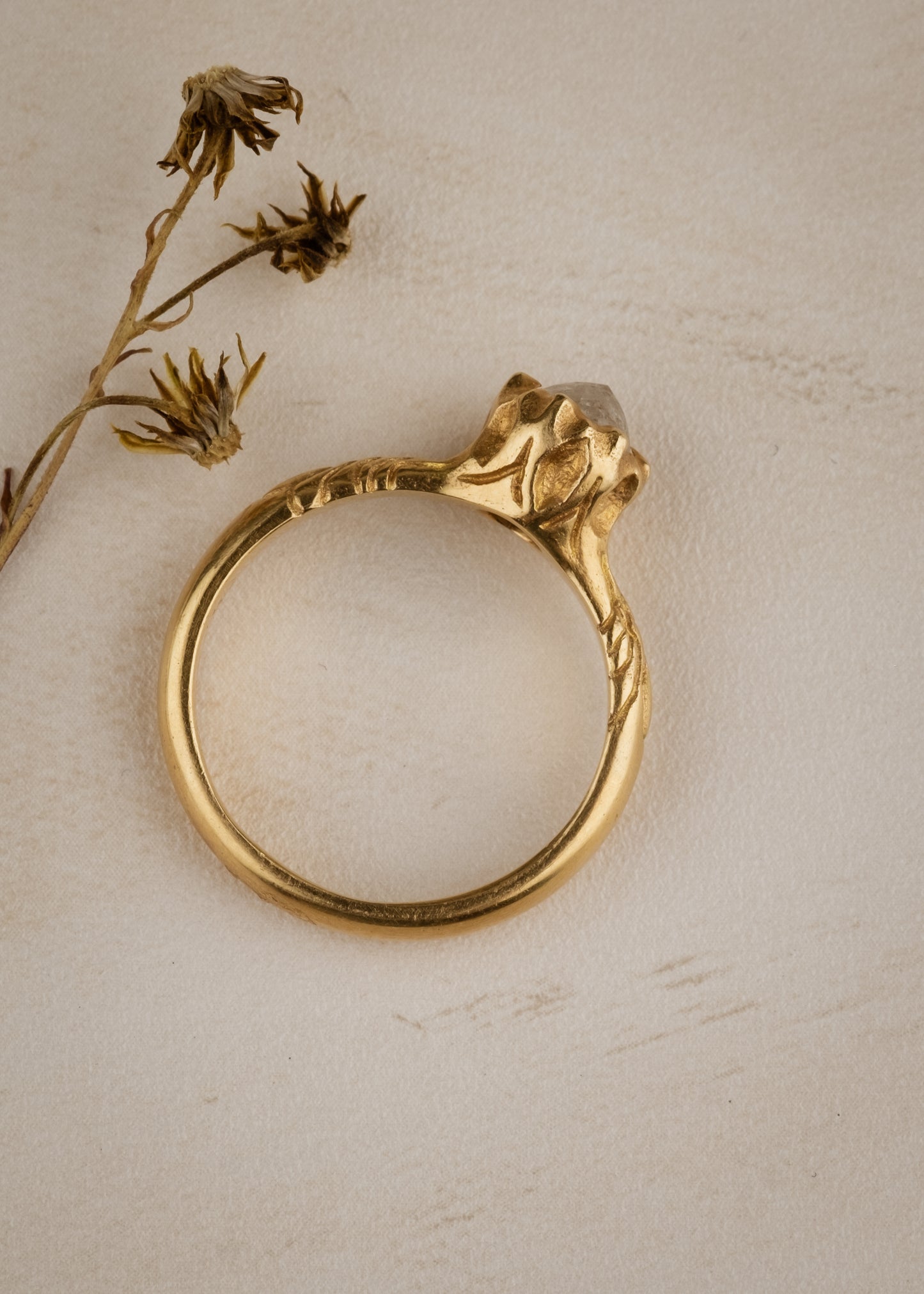 Like the haunting notes of a Glenn Miller Orchestra record, the Perfidia ring ascends to prominence on the finger to captivate all who bear witness to such beauty. Delicate details on the gold band give way to a textured pattern that holds a rose cut diamond, an exquisite work of ornate craftsmanship.