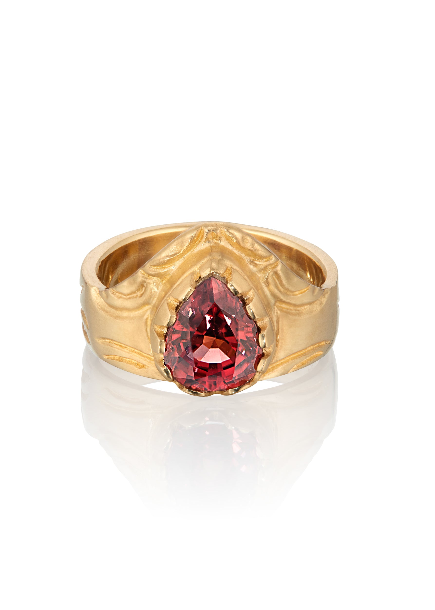 A study in strength and courage. The Valor ring relishes its prominence, the high arch shape a nod to the architectural element that can bear the unimaginable. A large reddish zircon nestles into the surrounding gold that has been hand-carved to showcase its beauty.
