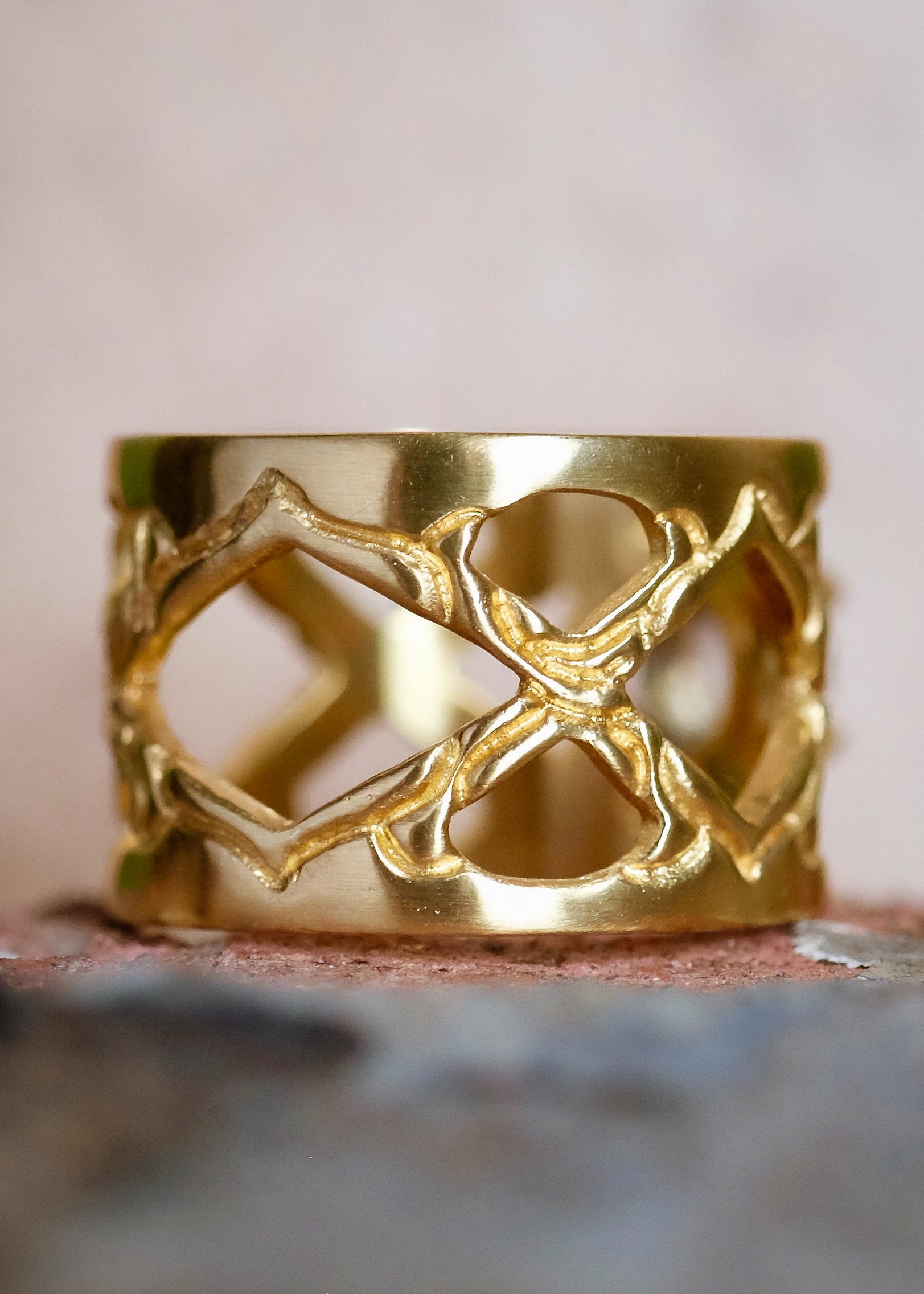 Like the Greek goddess of marriage, women, and family for which it is named, the Hera ring is a statement of strength, boldness, and beauty. Hand-carved gold creates a pattern of open-work arches on this band of eye-catching width; a grey rose cut diamond provides a stunning focal point.