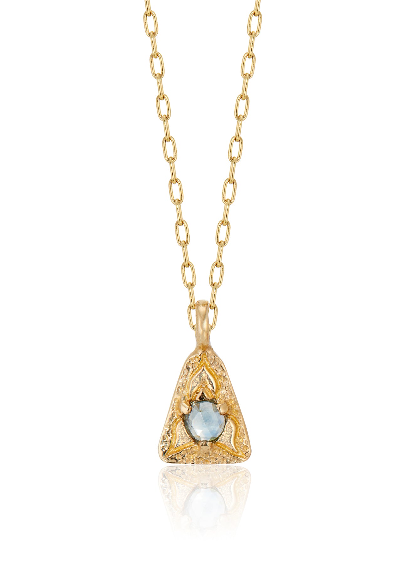 A celebration of resilience and strength. In nature, this water flower rises from the mud each day and blooms to its full potential. In architecture, the triangle is one of the strongest structures. The Blue Lotus necklace merges the natural elements of a rose cut blue sapphire and hand-carved gold lotus petals with an architecturally-inspired triangular pendant for a necklace of beauty and balance. 