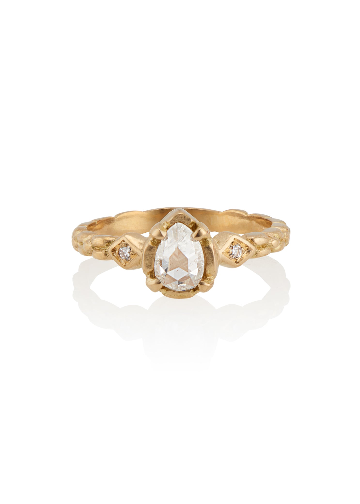 Stately and elegant, the Majestic ring is rich in exquisitely carved gold detail along the band, securing a pear-shaped rose cut diamond that commands attention—a piece evocative of royalty. 