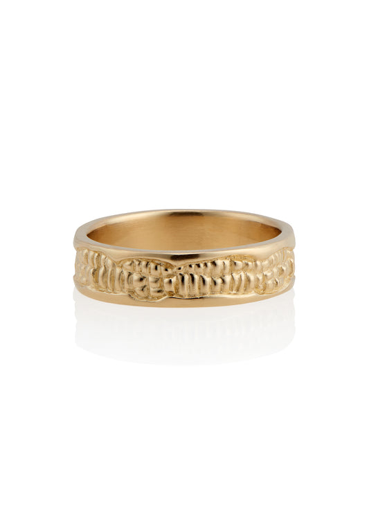 Inspired by the craftsmanship of intricately carved antique woodwork, the Hilt is a study in solidity. A captivating pattern gleams around this gold ring—an ideal wedding band for one with a discerning eye for design. 