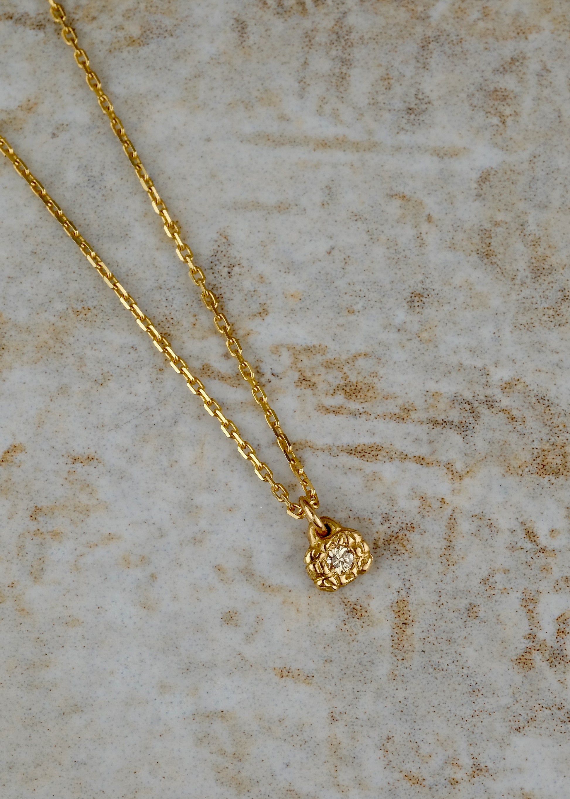 Textured gold, hand-carved to reveal its lustre, surrounds a gleaming diamond to create the Barre necklace—an essential and elegant design that calls to mind the effortless grace of a ballerina at the barre.