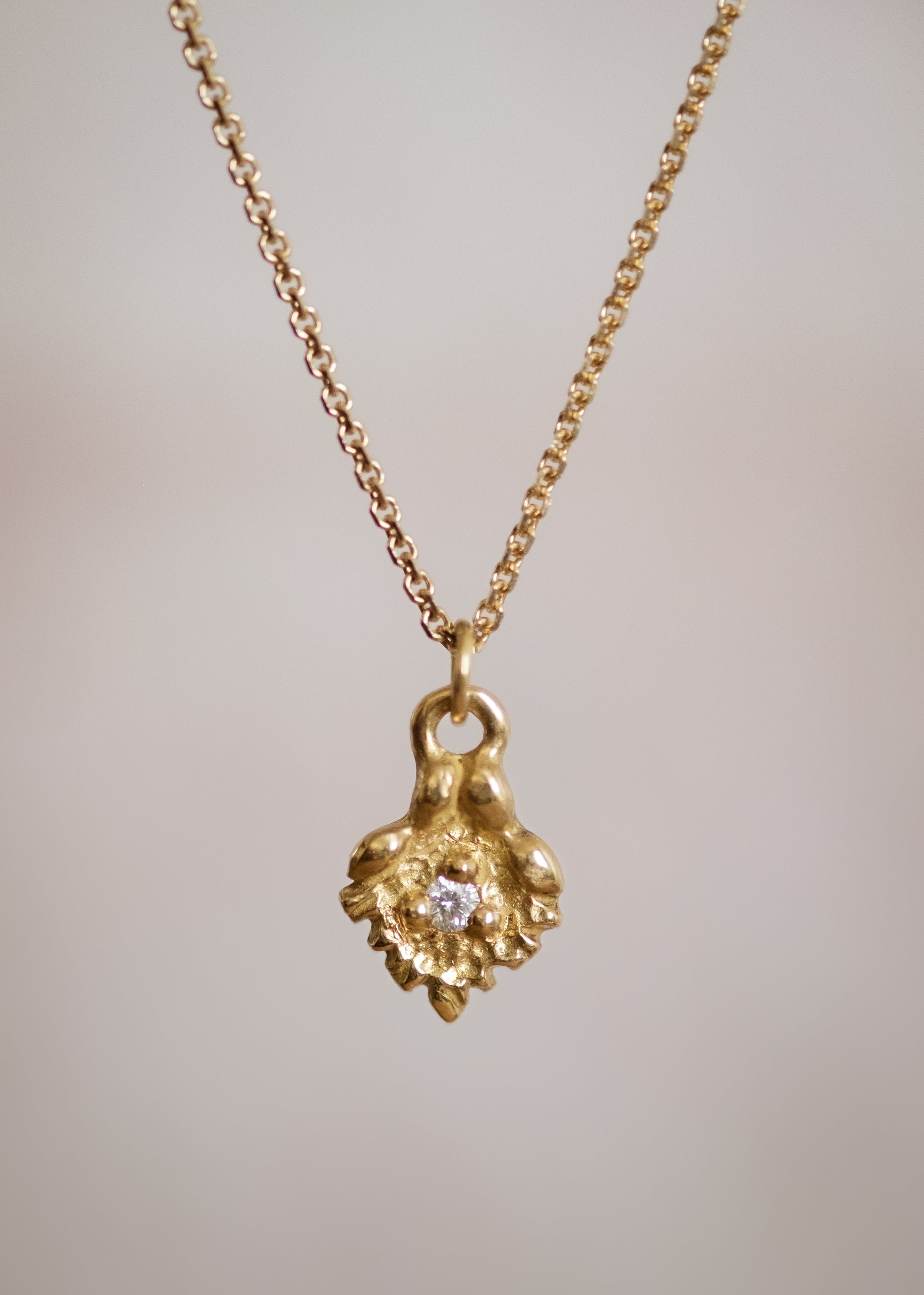 Like a small cabin nestled in the verdant mountainside of the Swiss Alps, the Chalet necklace invites a sense of wanderlust and adventure. Intricate textures give way to a single diamond that sparkles brilliantly against the gold that surrounds it—a snow-capped mountain top gleaming under the radiant warmth of the sun. 