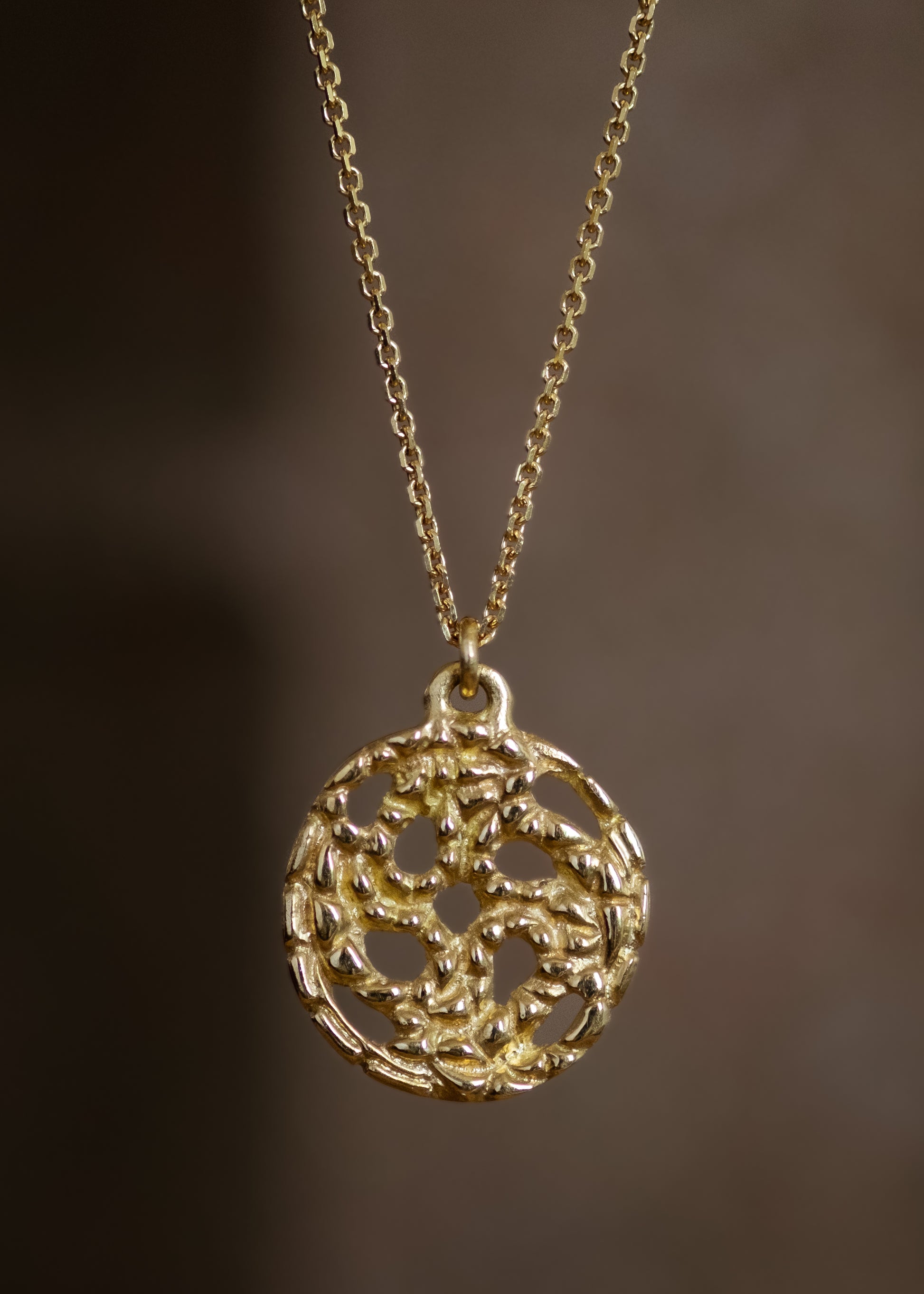 A passport to another world. With its intricate hand-carved texture and open-work design, the Token necklace calls to mind a lucky coin that opens the gate to where adventure lies, just beyond. 