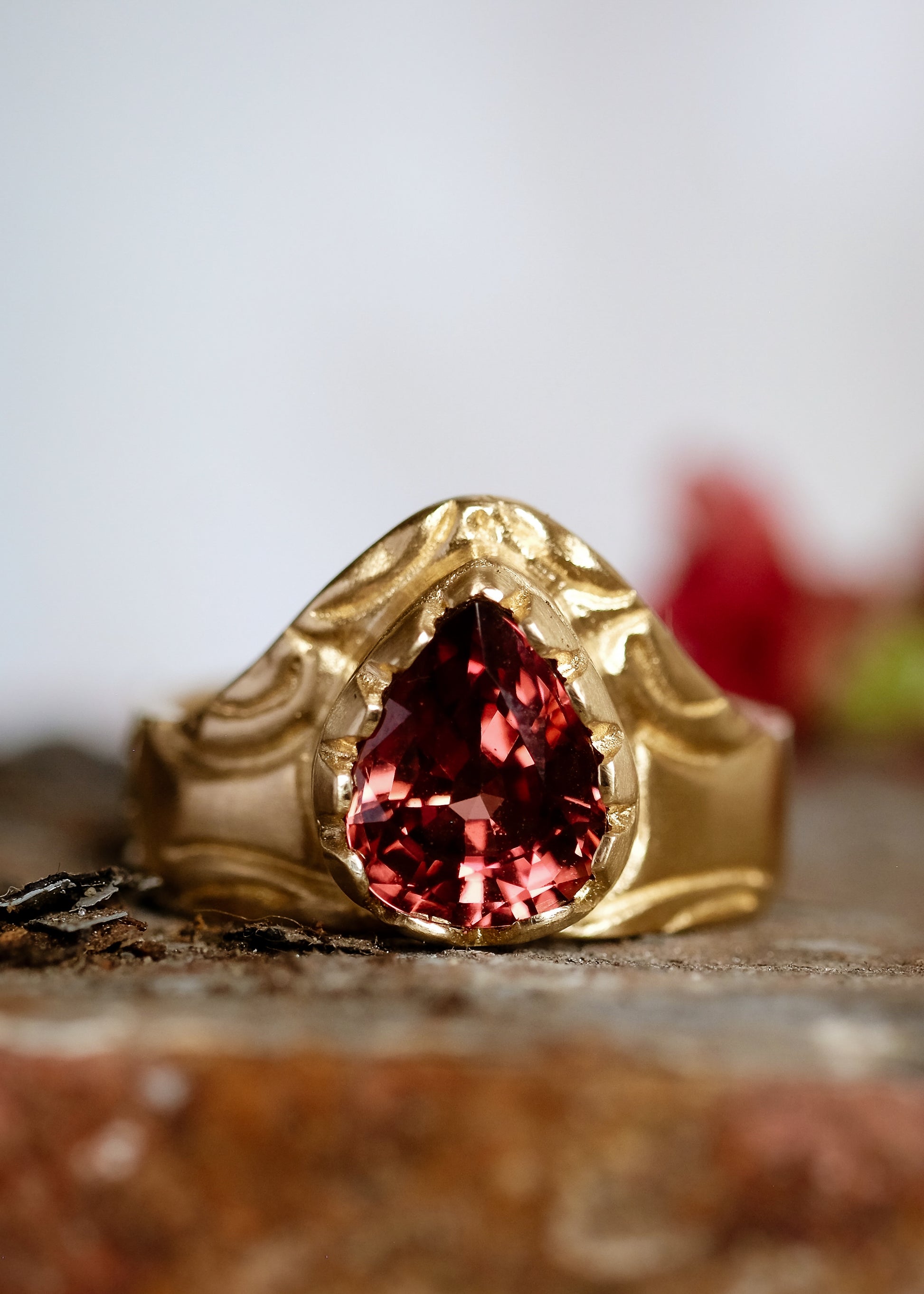 A study in strength and courage. The Valor ring relishes its prominence, the high arch shape a nod to the architectural element that can bear the unimaginable. A large reddish zircon nestles into the surrounding gold that has been hand-carved to showcase its beauty.
