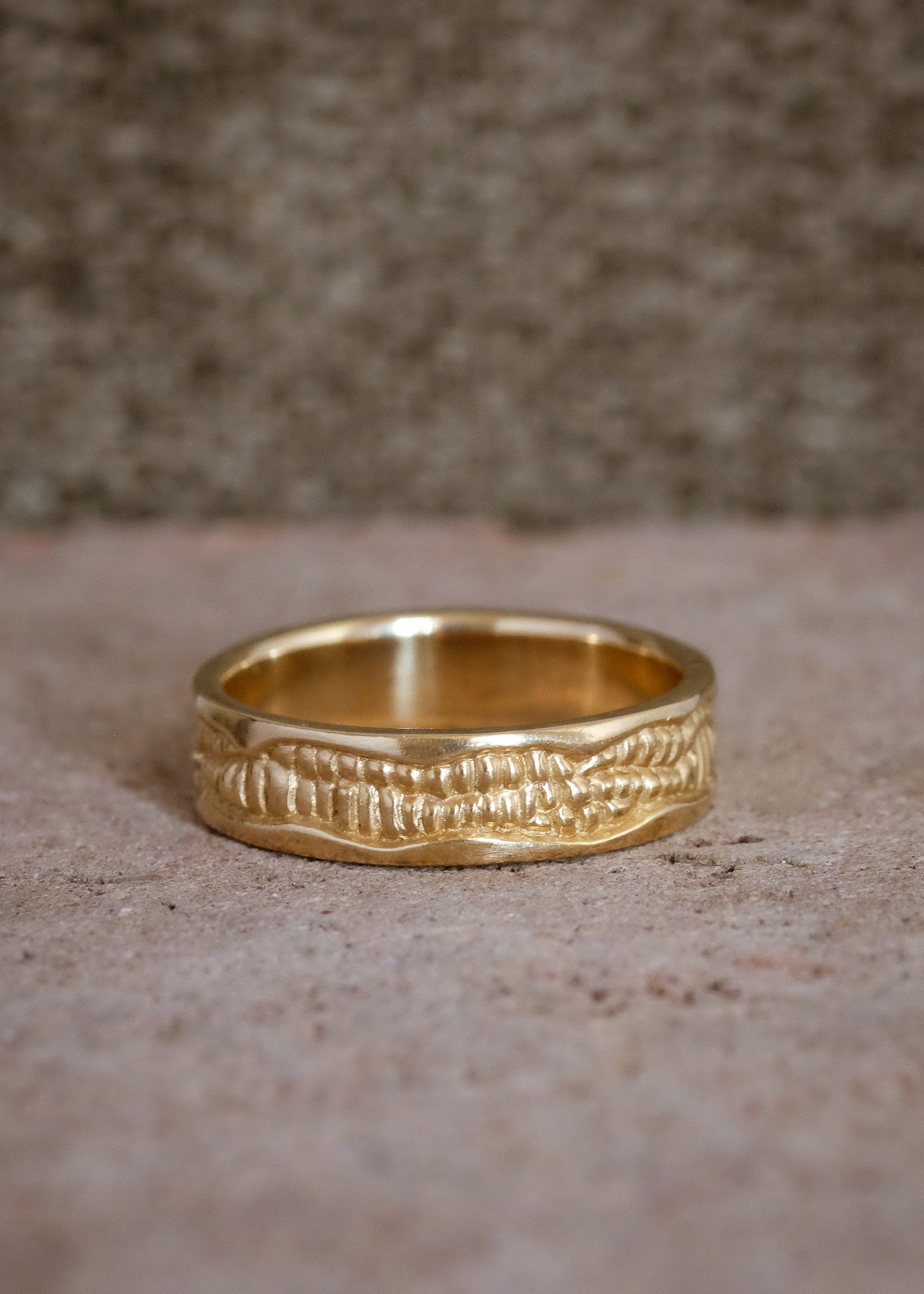Inspired by the craftsmanship of intricately carved antique woodwork, the Hilt is a study in solidity. A captivating pattern gleams around this gold ring—an ideal wedding band for one with a discerning eye for design. 