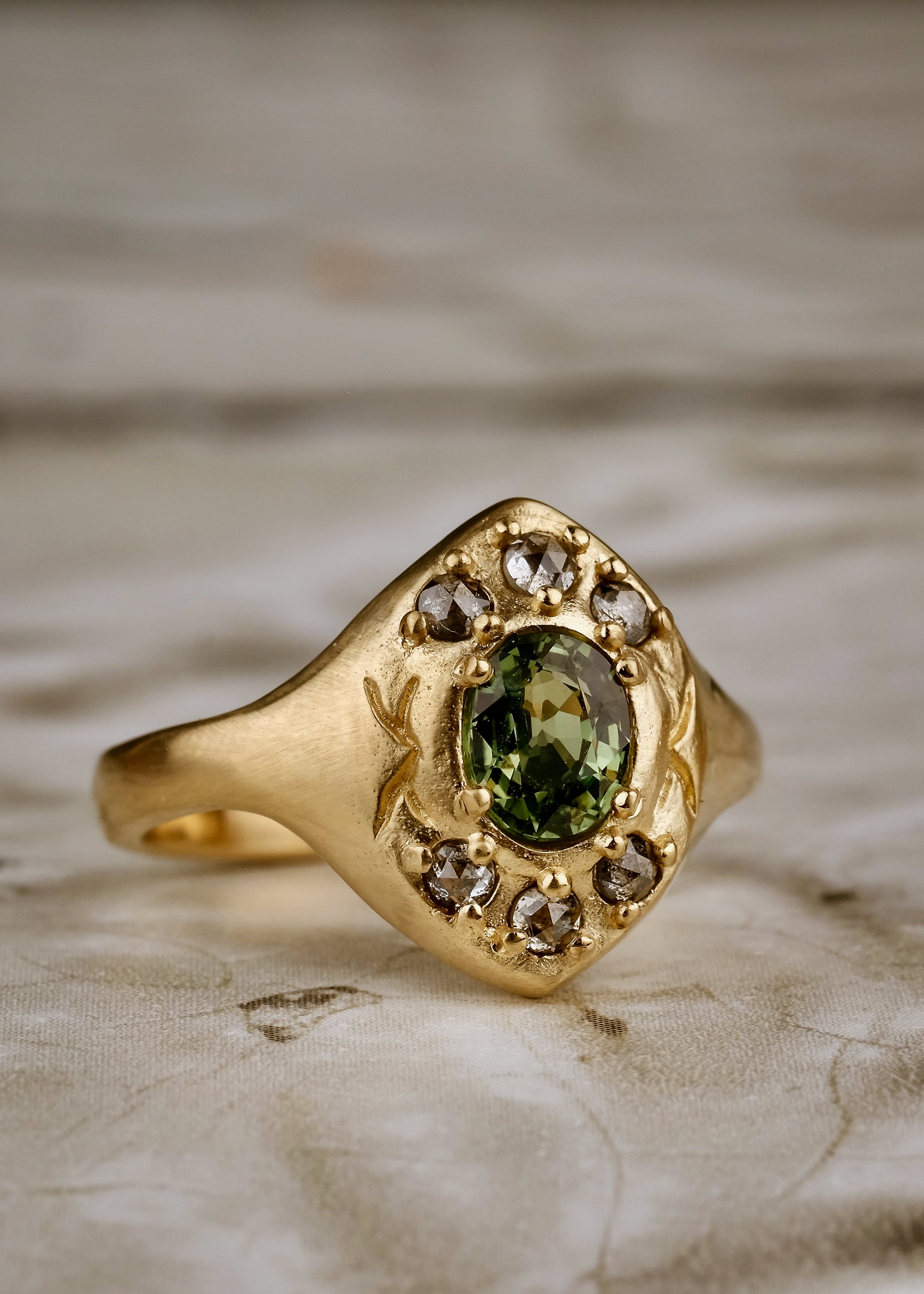 A resplendent portal to a bygone era, the Lucent ring borrows inspiration from the Gothic arches of a treasured riverside cathedral. Aligned to highlight the points of the arches, rose cut diamonds and a breathtaking green sapphire appear lit from within, like sunlight streaming through stained glass. A masterful, timeless piece of jewelry.