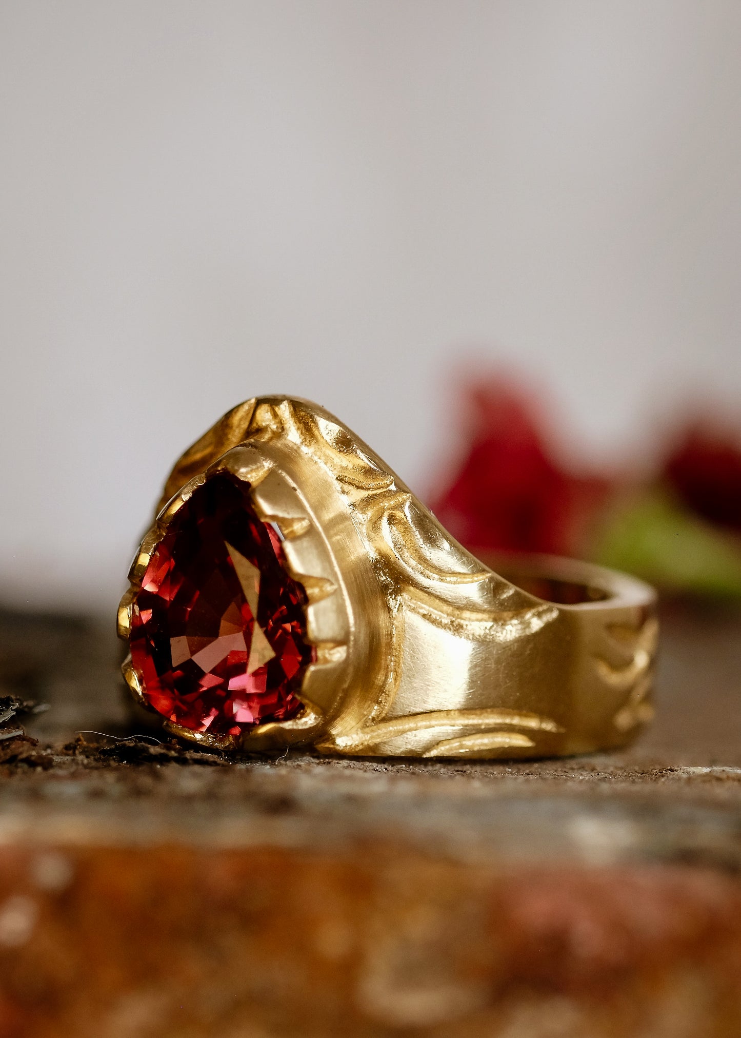 A study in strength and courage. The Valor ring relishes its prominence, the high arch shape a nod to the architectural element that can bear the unimaginable. A large reddish zircon nestles into the surrounding gold that has been hand-carved to showcase its beauty.