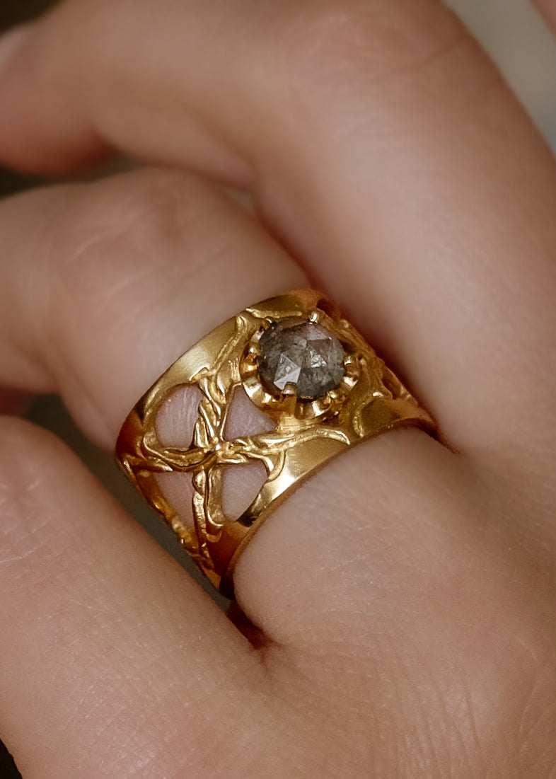 Like the Greek goddess of marriage, women, and family for which it is named, the Hera ring is a statement of strength, boldness, and beauty. Hand-carved gold creates a pattern of open-work arches on this band of eye-catching width; a grey rose cut diamond provides a stunning focal point.